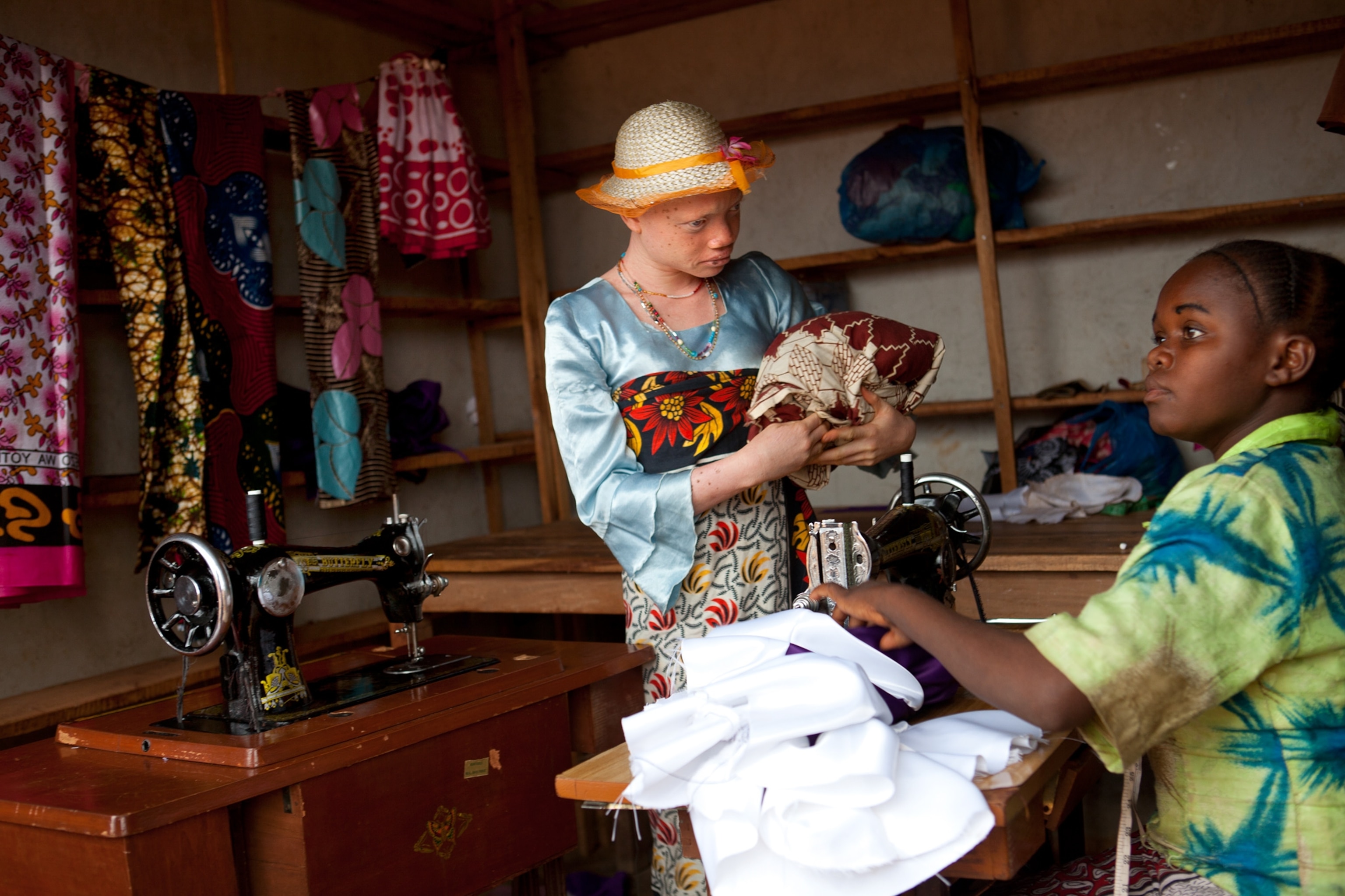 Angel Salvatory shopping for cloth to protect himself from the sun, Kabanga Village, Tanzania