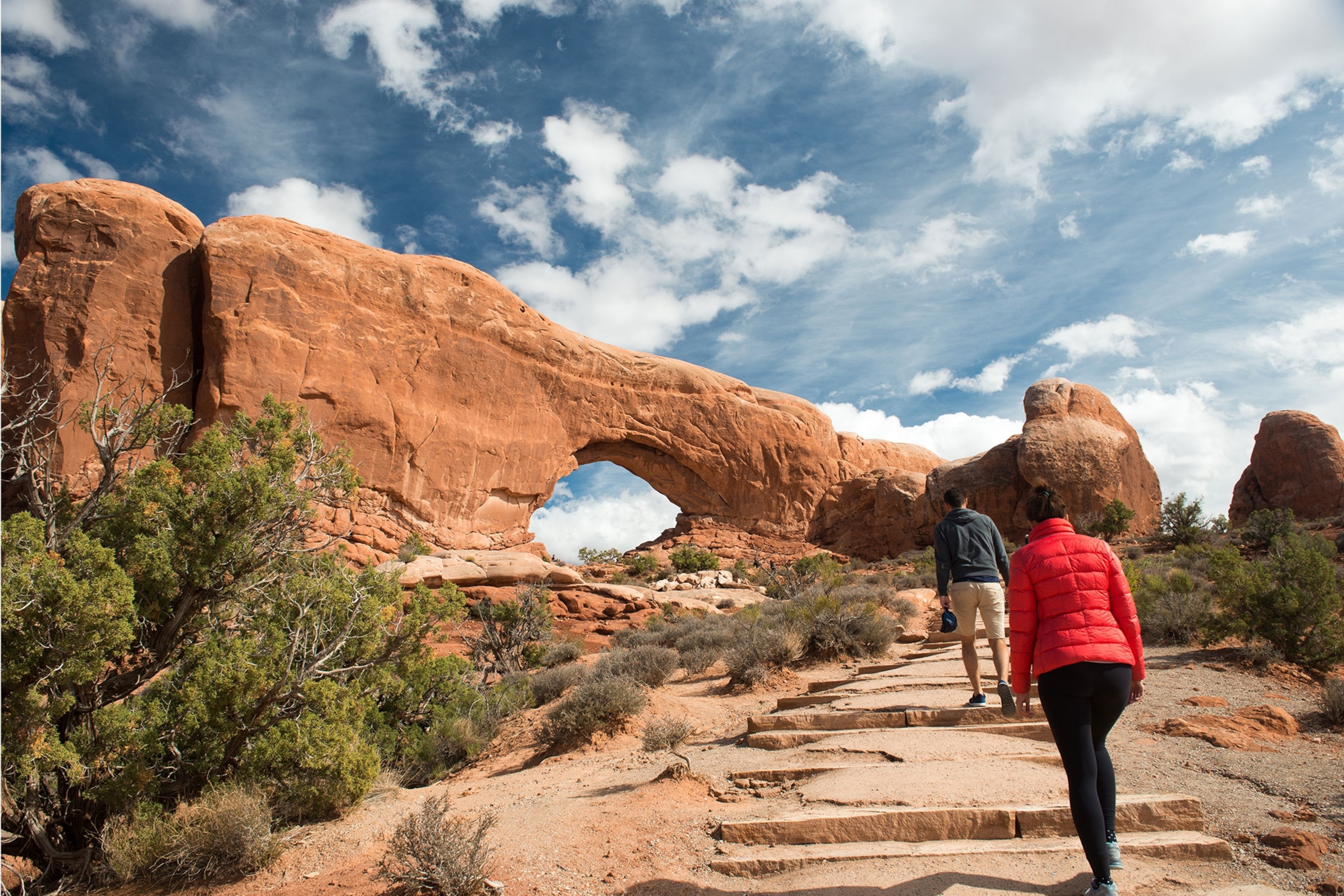 Hikers walking up slope to arch