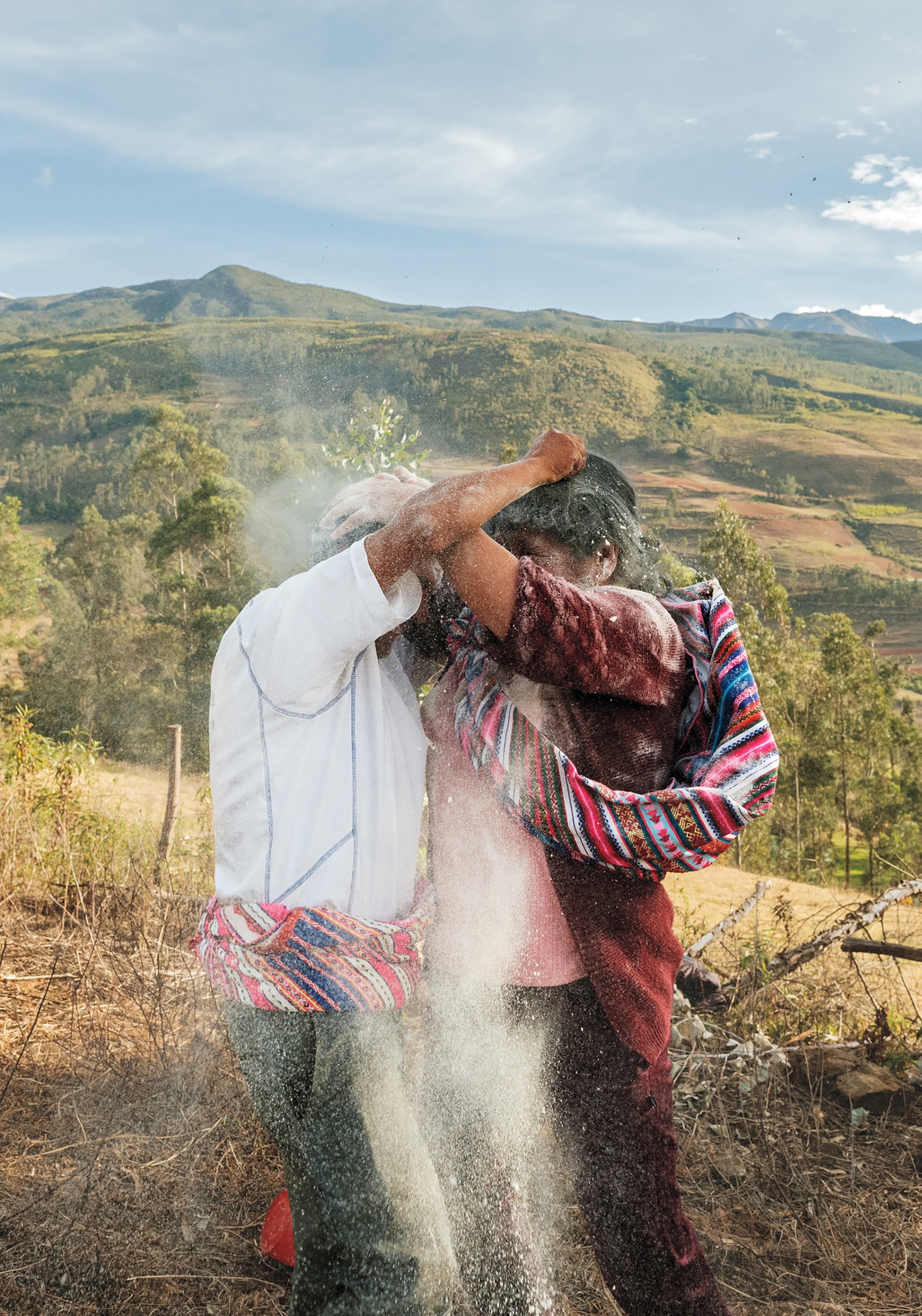 A man and a woman throw flour on each other's heads in celebration.