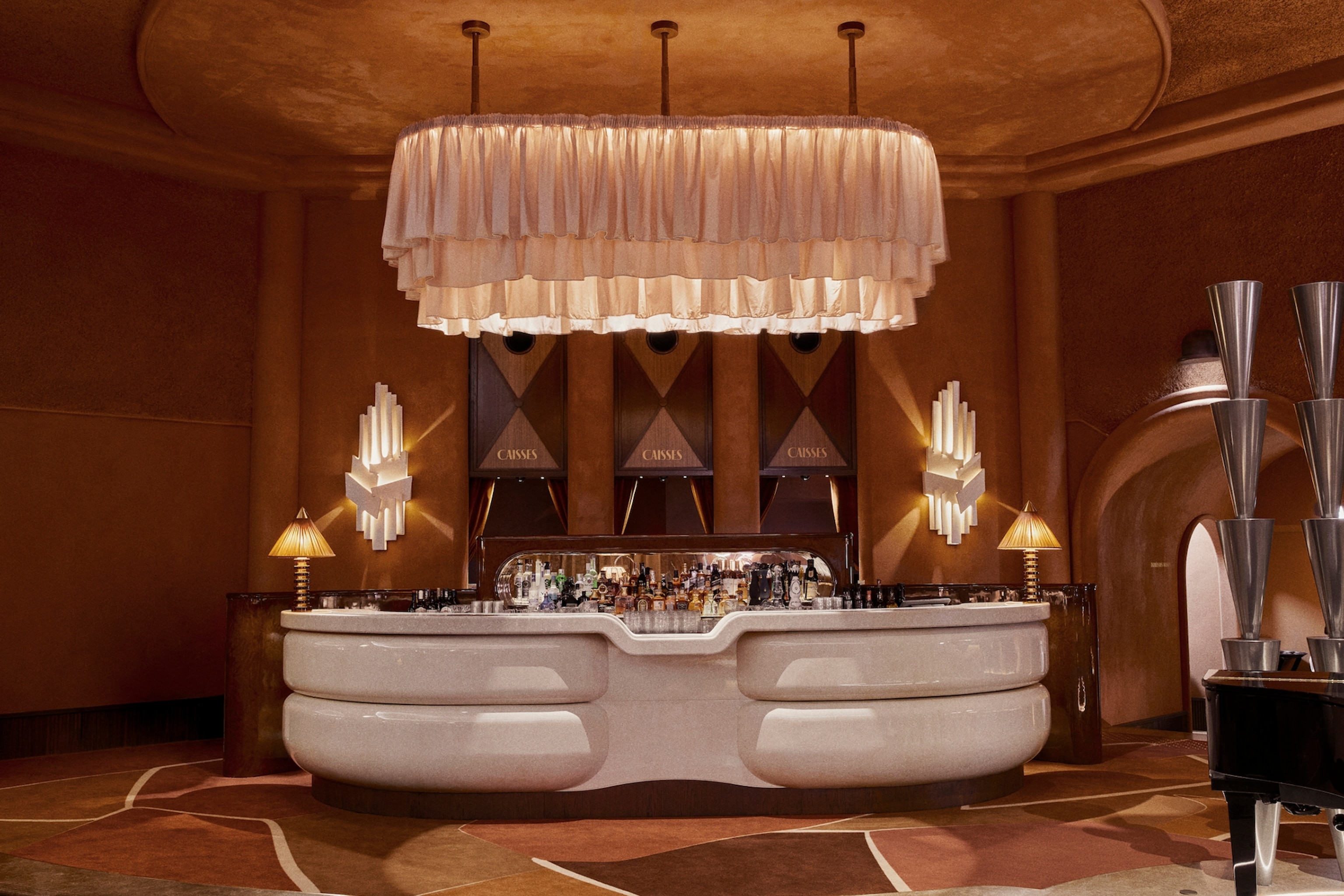A free-standing, cloud-shaped bar with curtain lamp hung above and art deco features.