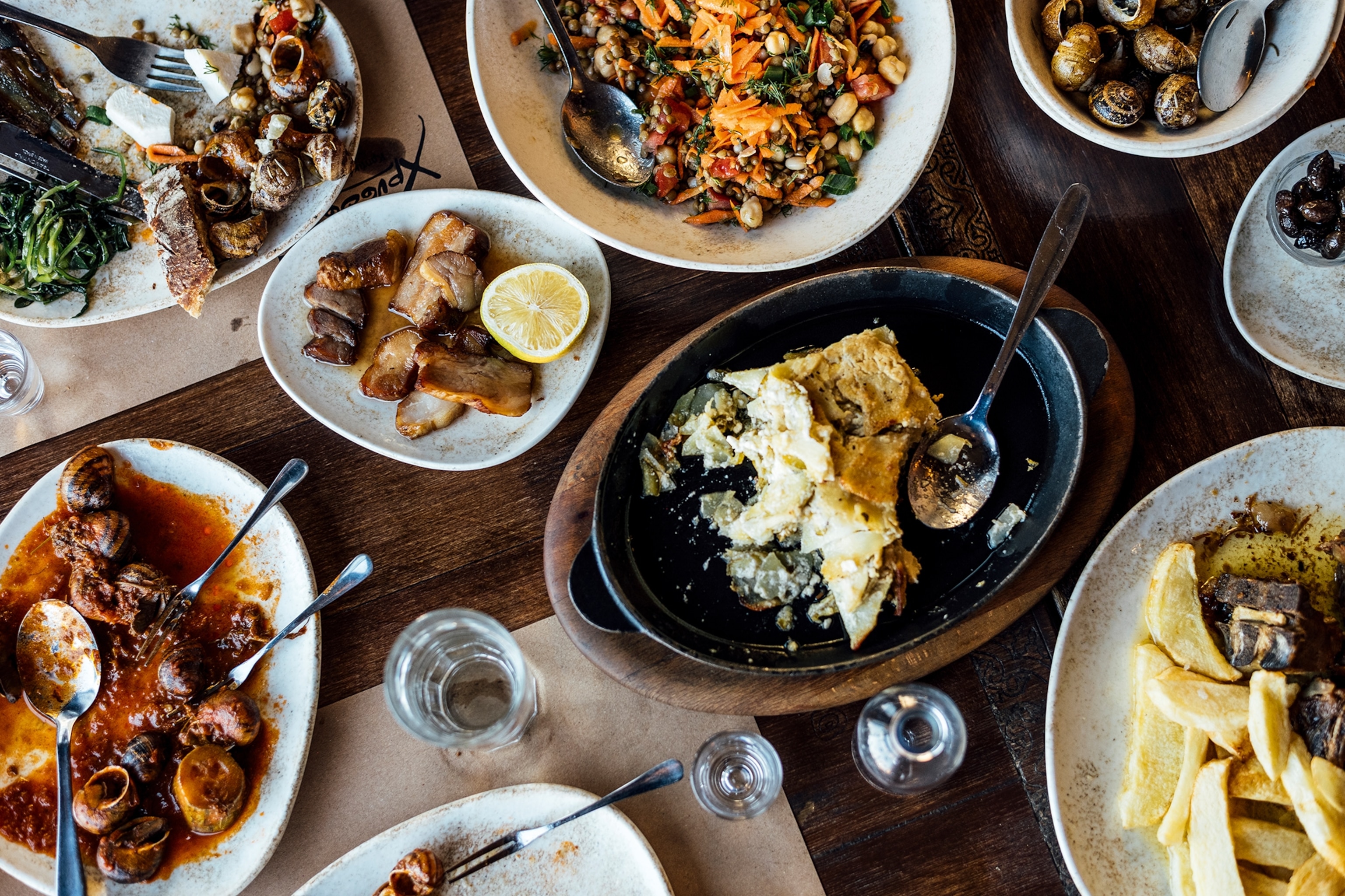 Ariel view of a wooden table laid with plates to share.