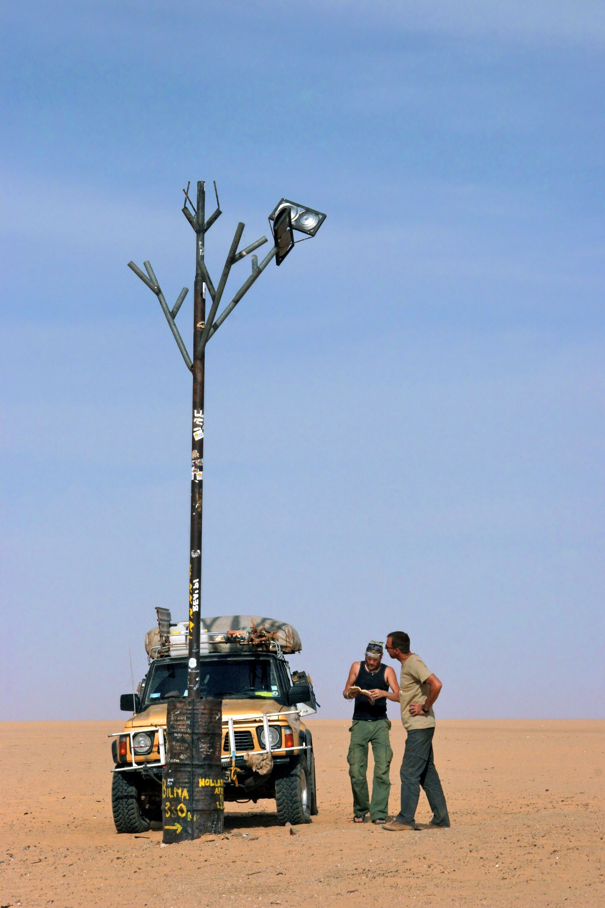 Tourists at the replica of the Arbre du Tenere in the Sahara desert, Niger