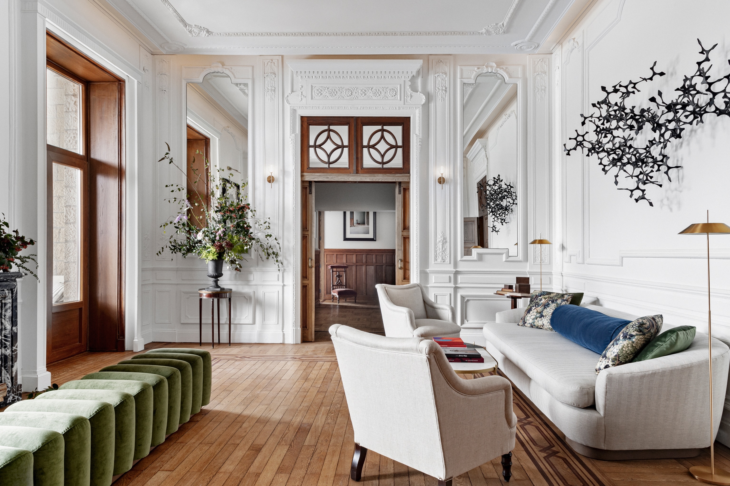 Hotel room with white sofas, white walls and a big wooden door
