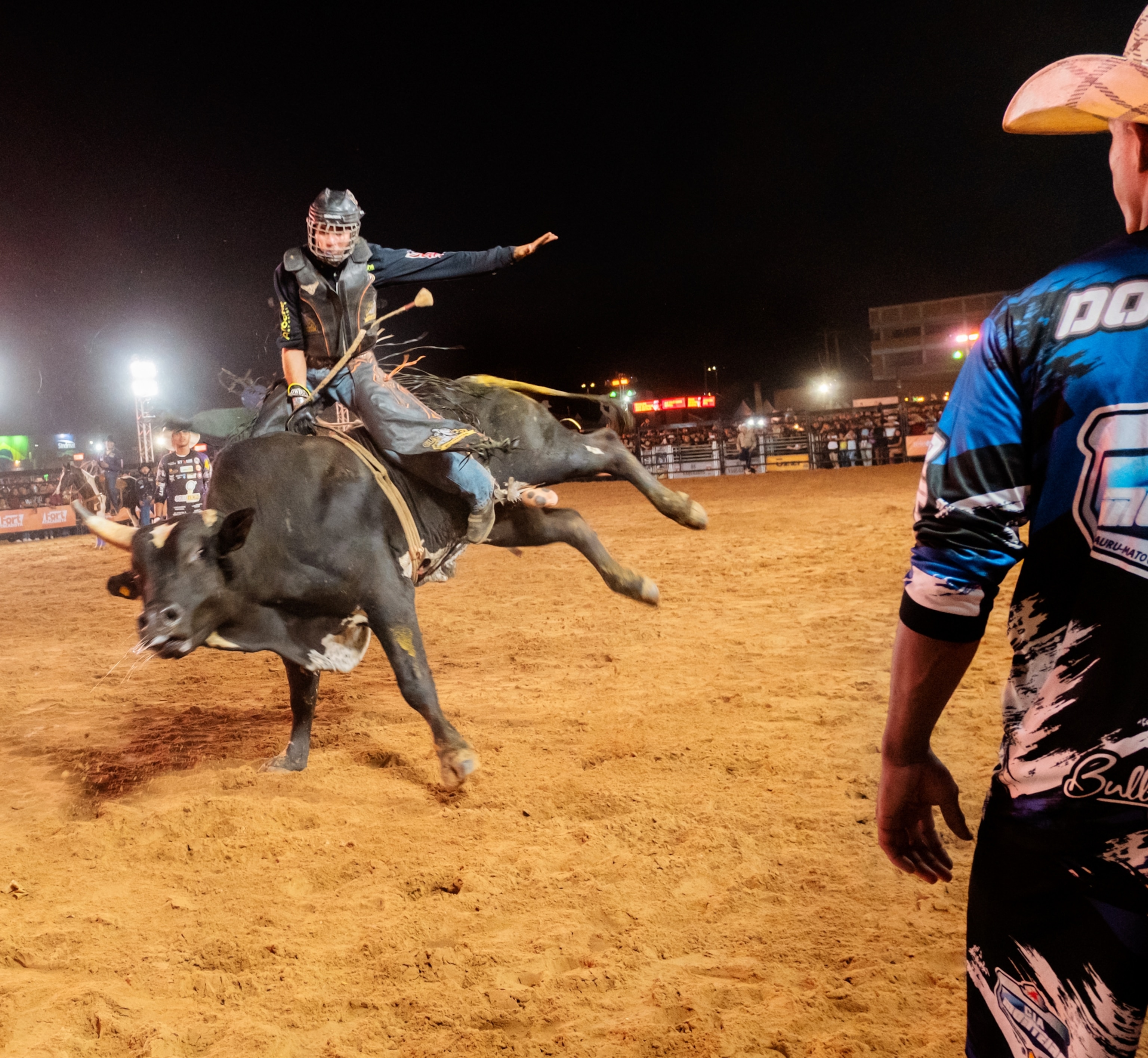 A man balancing while riding a bull.