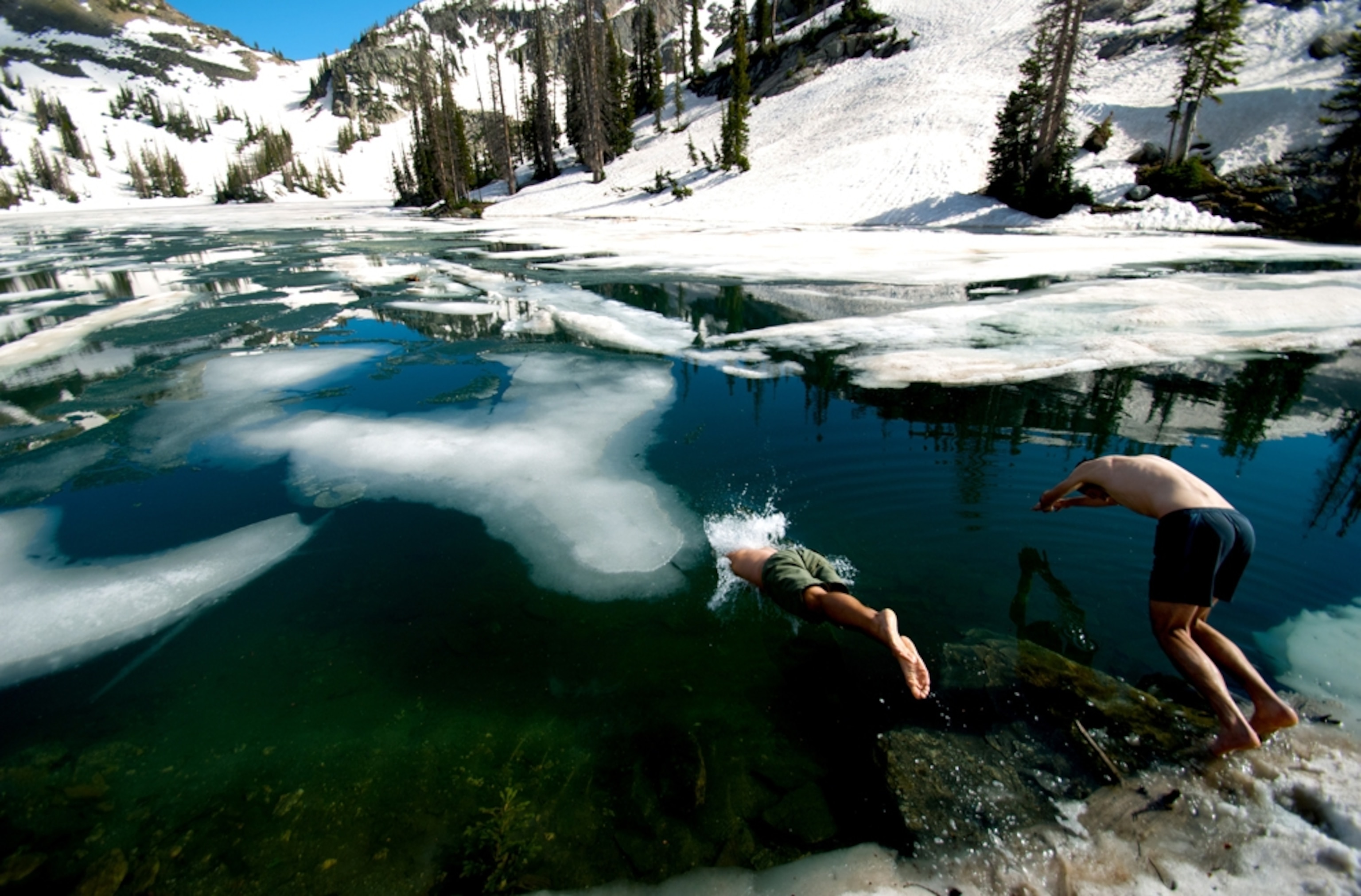 Hikers jump into a frozen lake