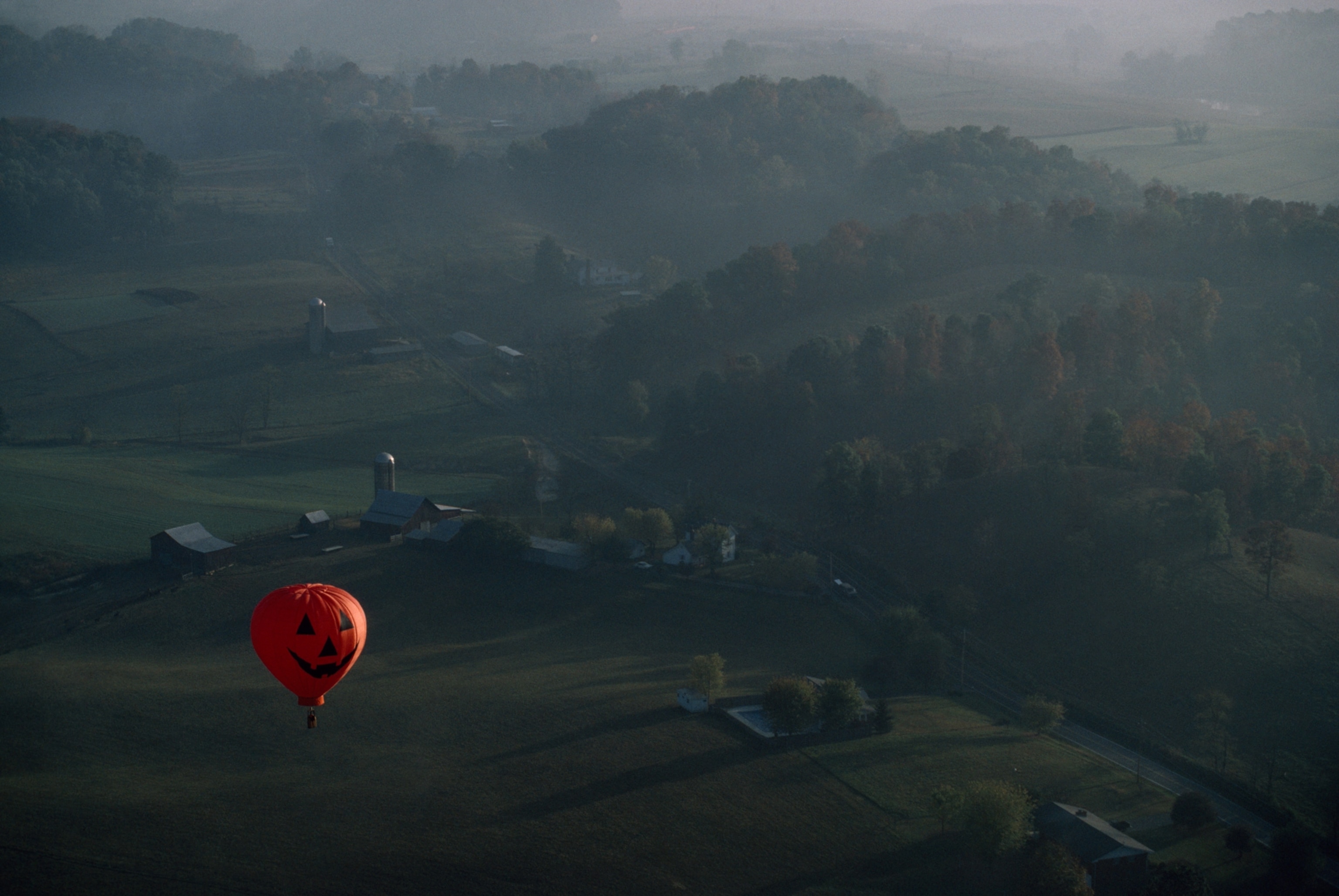 Picture of a hot air balloon decorated as a jack-o-lantern drifting over northeastern Tennessee