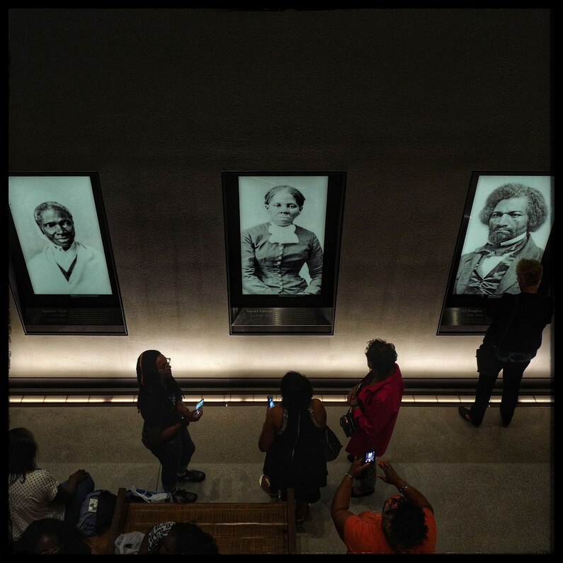 Portraits of Sojourner Truth, Harriet Tubman, and Frederick Douglass line a wall at the African American Museum of History and Culture during the museum's opening weekend.