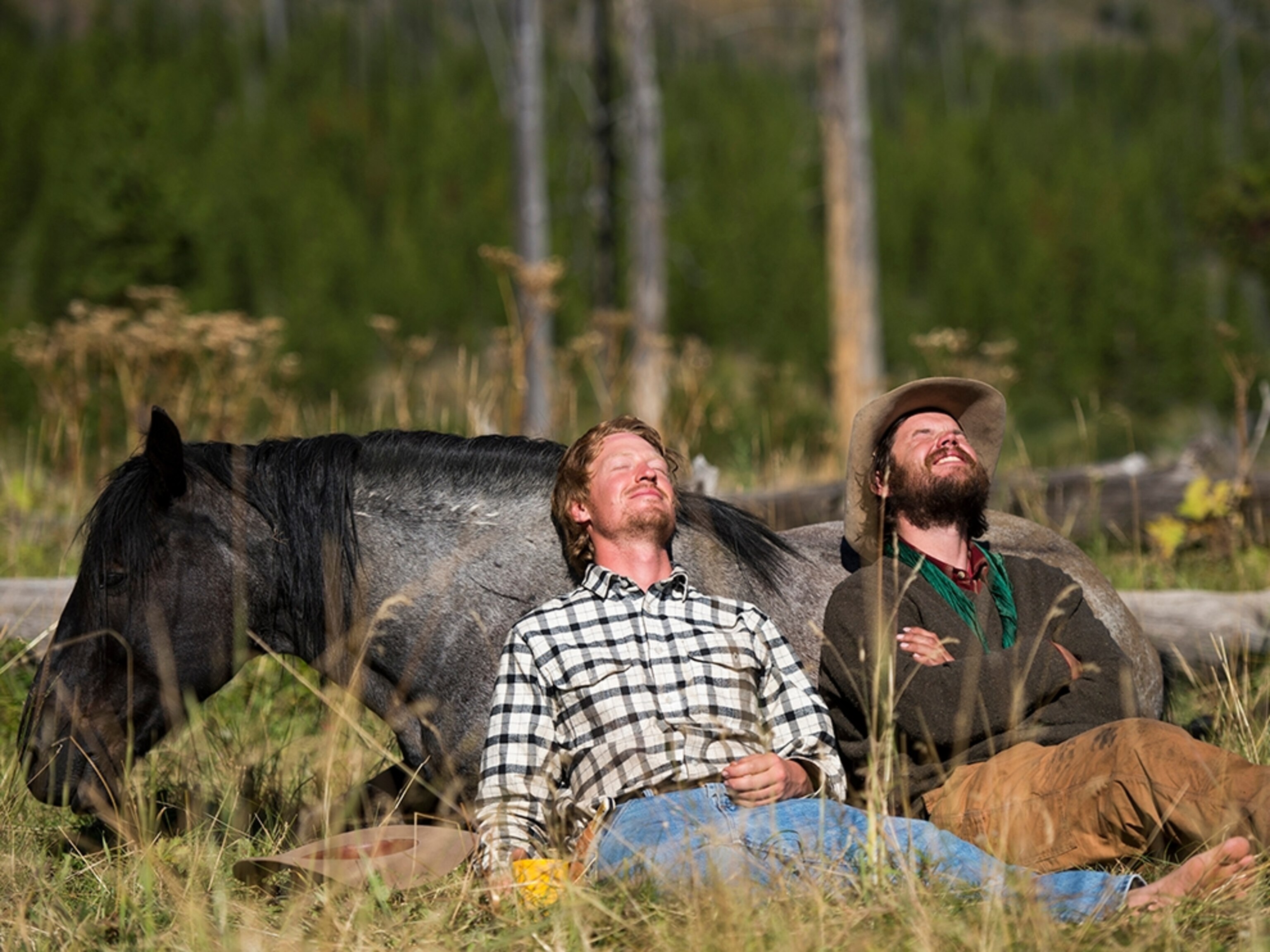 Ben Masters and Ray Knell resting up against Ray's horse.