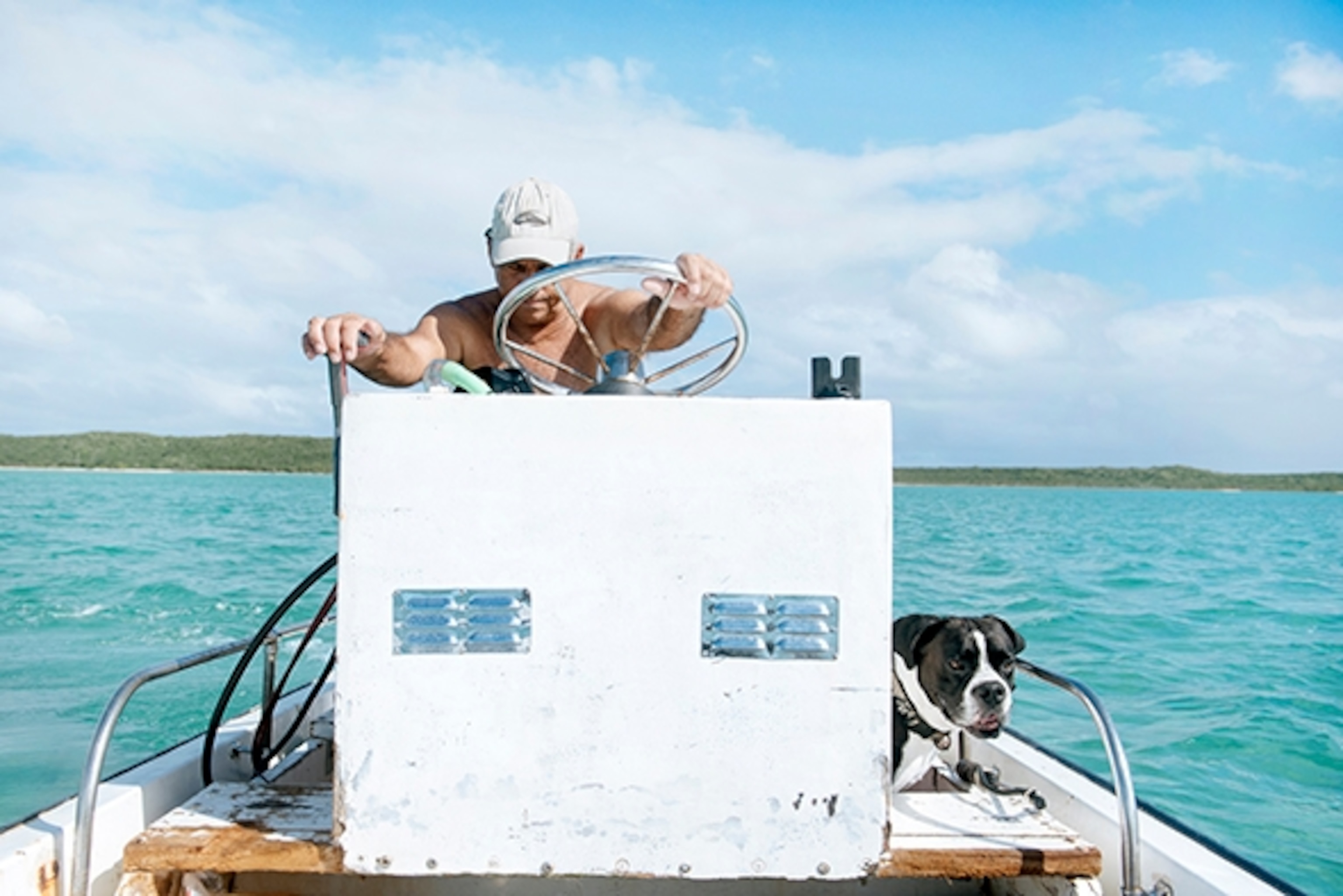 Charlie Beedy and his dog, Nick, man the wheel house of a small skif; Photograph by Max Lowe