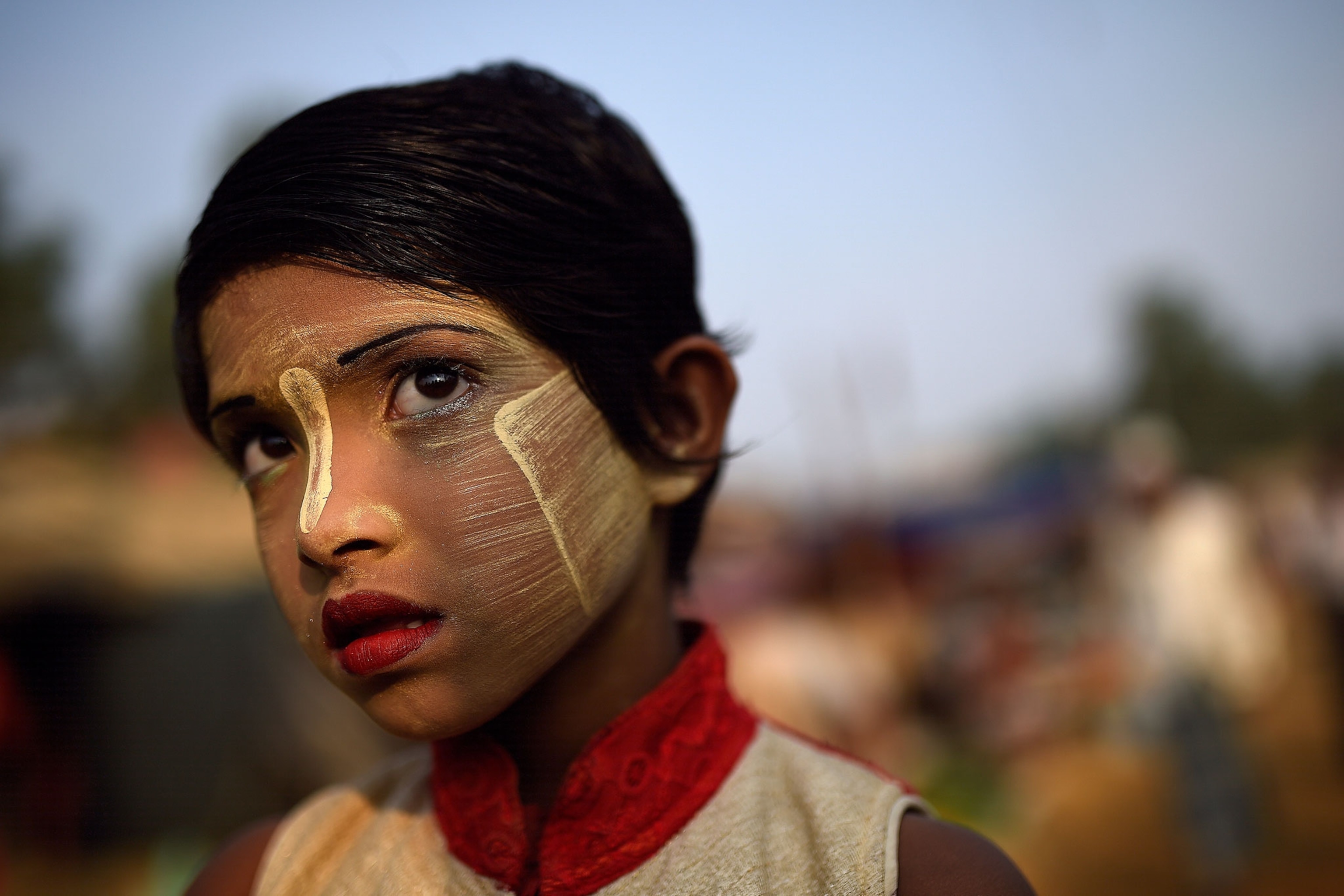 a Rohingya girl wearing paint on her face to protect her from the sun