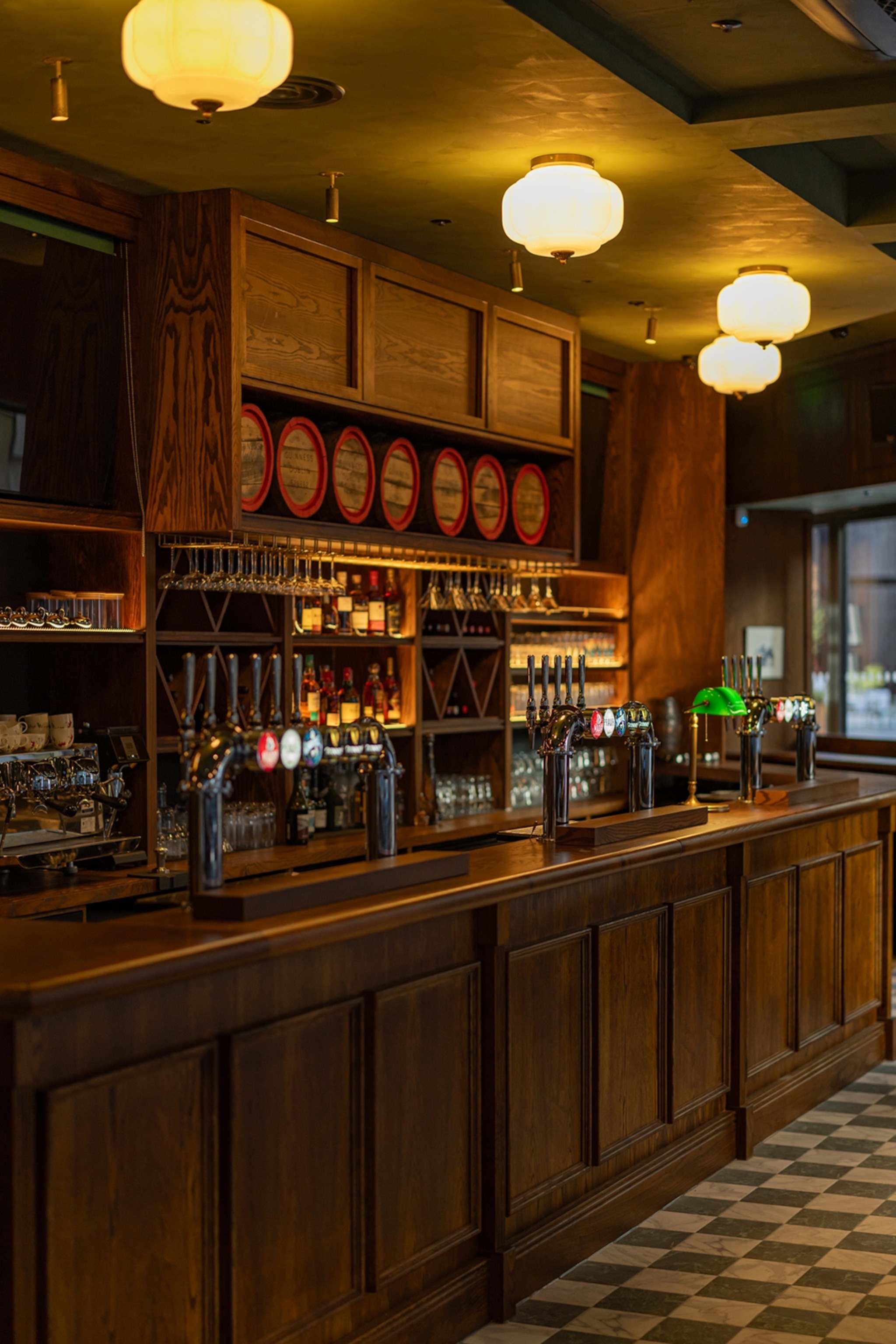 The cosy and warm interiors of a pub bar with decorative barrels.