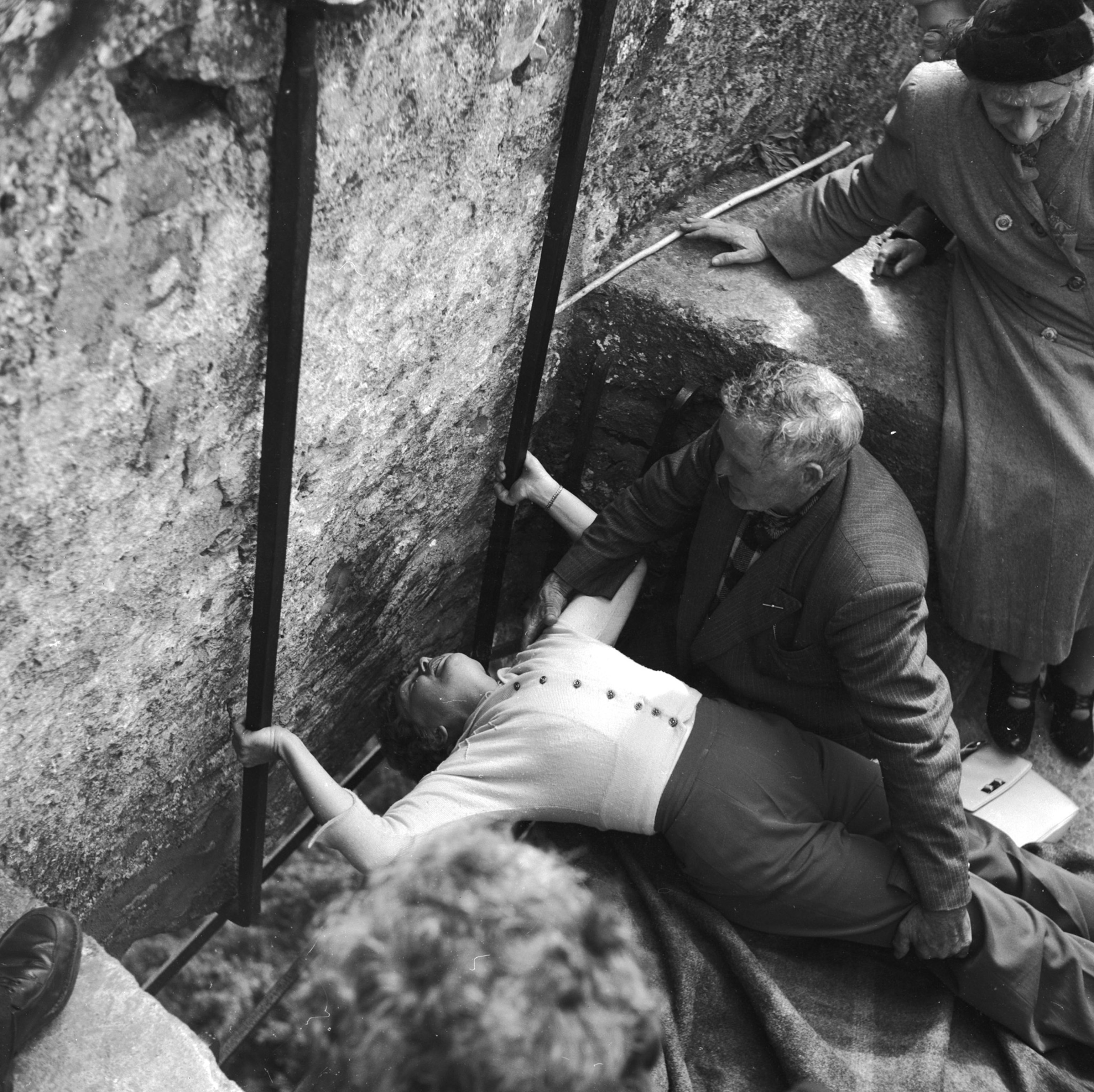 a woman bending to kiss the Blarney Stone at Blarney Castle in Ireland