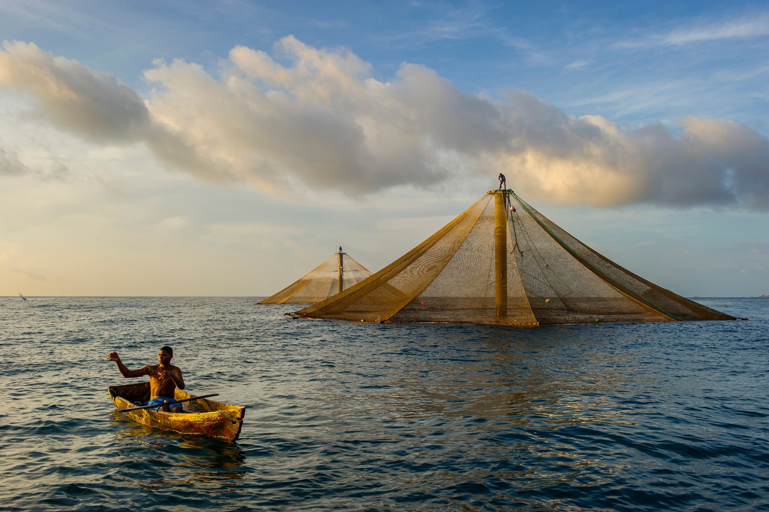 A local Panamanian fisherman fishes from his canoe near the fish cages owned by Open Blue Sea Farms.