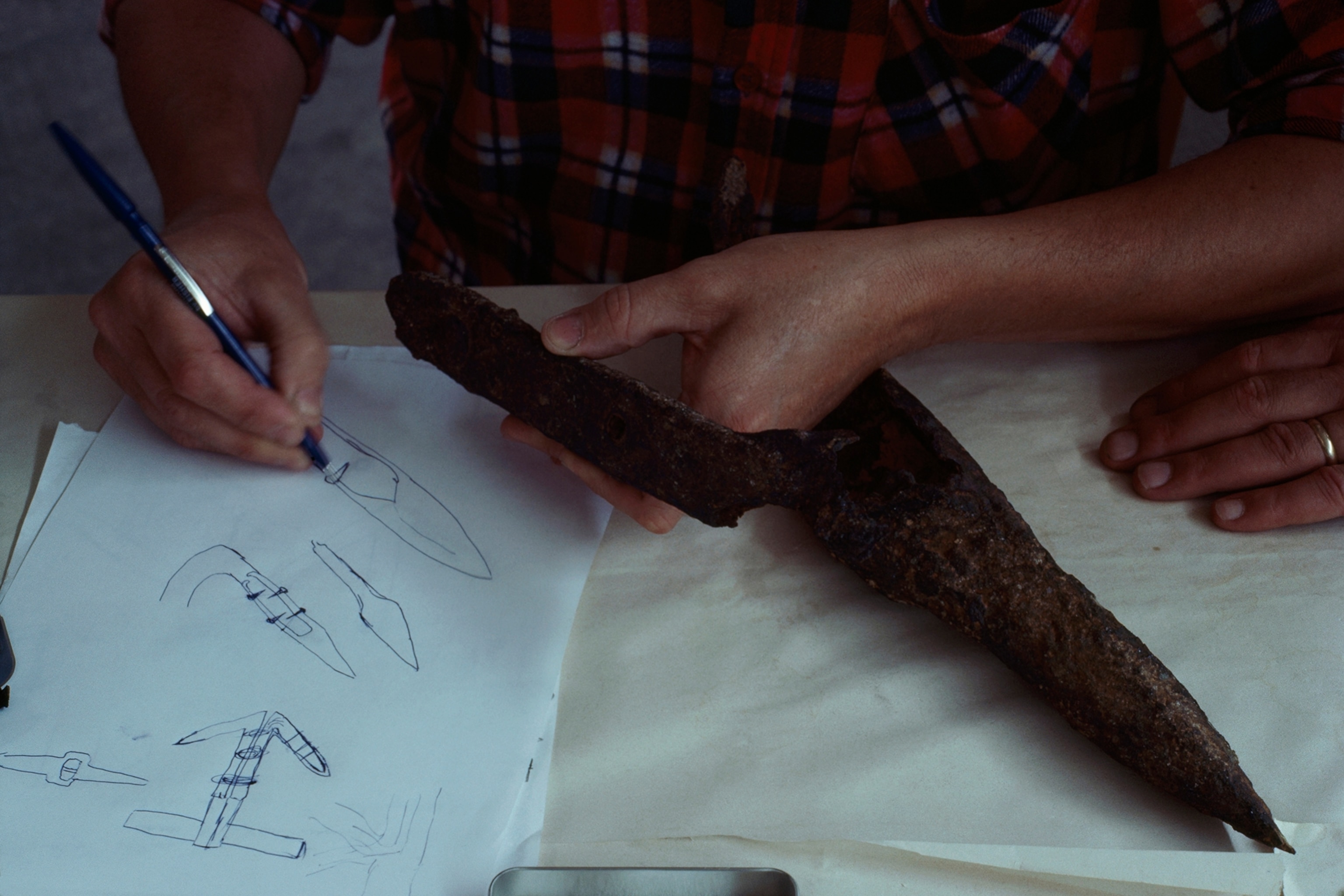 An archeologist sketches piece of an ancient anchor from Herculaneum.
