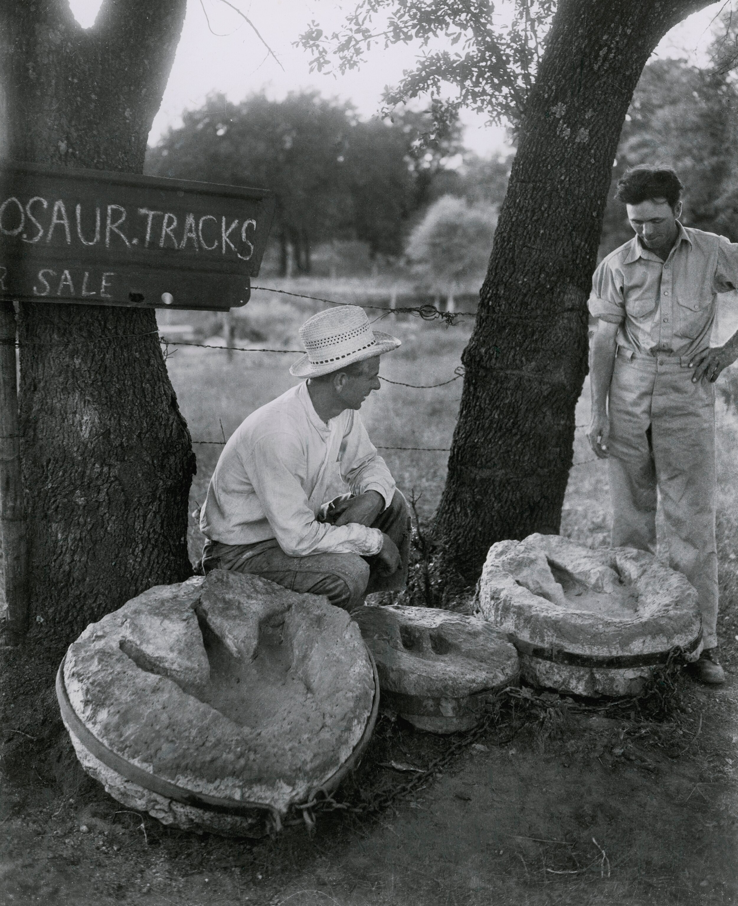 How about buying a dinosaur track today? Jim Ryals (center), running local dinosaur track market, hoped for a big boom in sales during the expeditions stay on the Paluxy RIver. Almost only buyers were infrequent rock gardeners willing to pay $15 to $25 per specimen. Roadside samples were kept chained together to prevent easy shop-lifting.