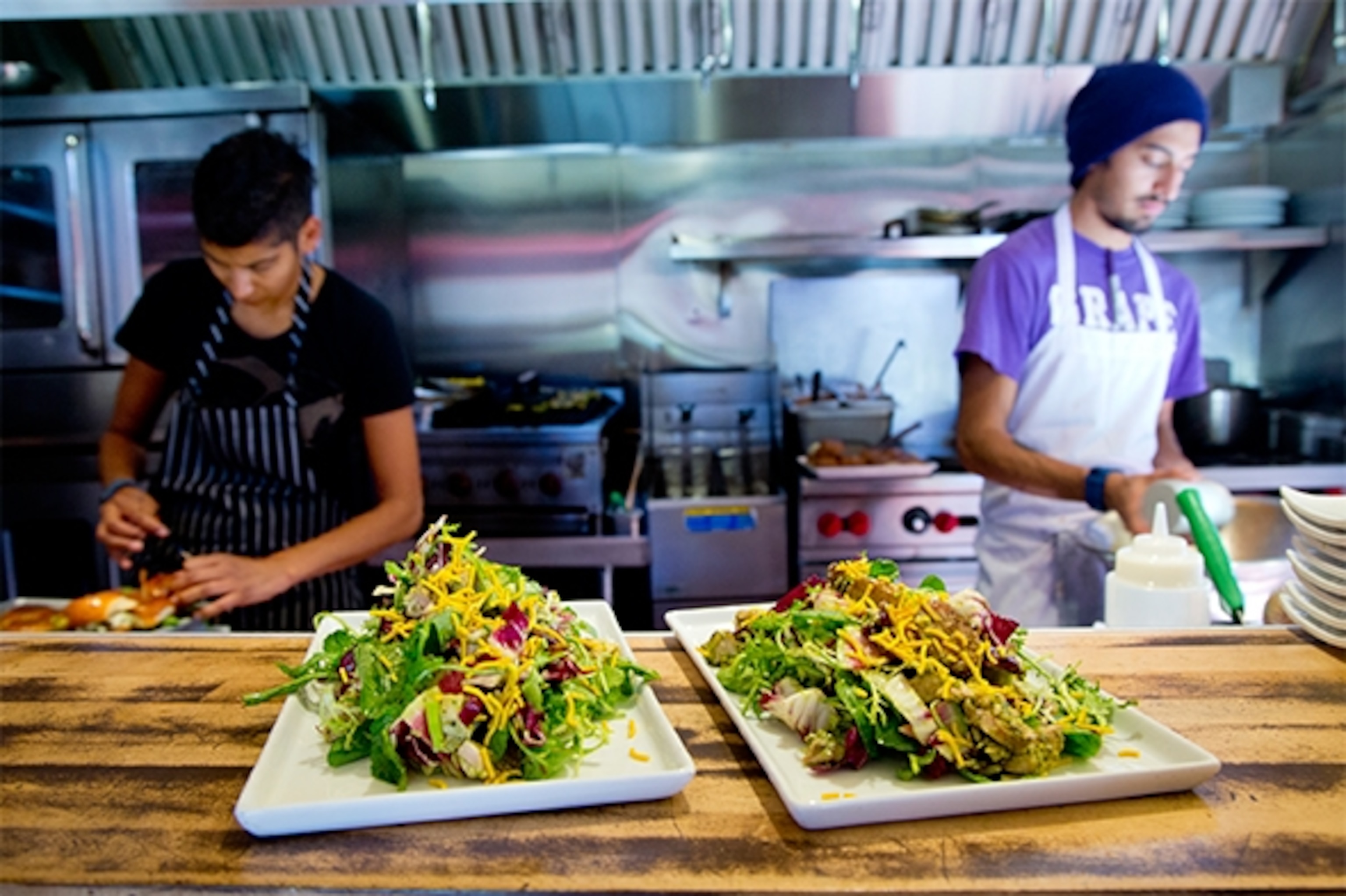 At Juhu Beach Club, owner Preeti Mistry (left) prepares Indian street-food-inspired favorites, such as the Navi Mumbai chicken salad, made with seasonal greens, roasted root veggies, and grilled green chili chicken. (Photograph by Catherine Karnow)