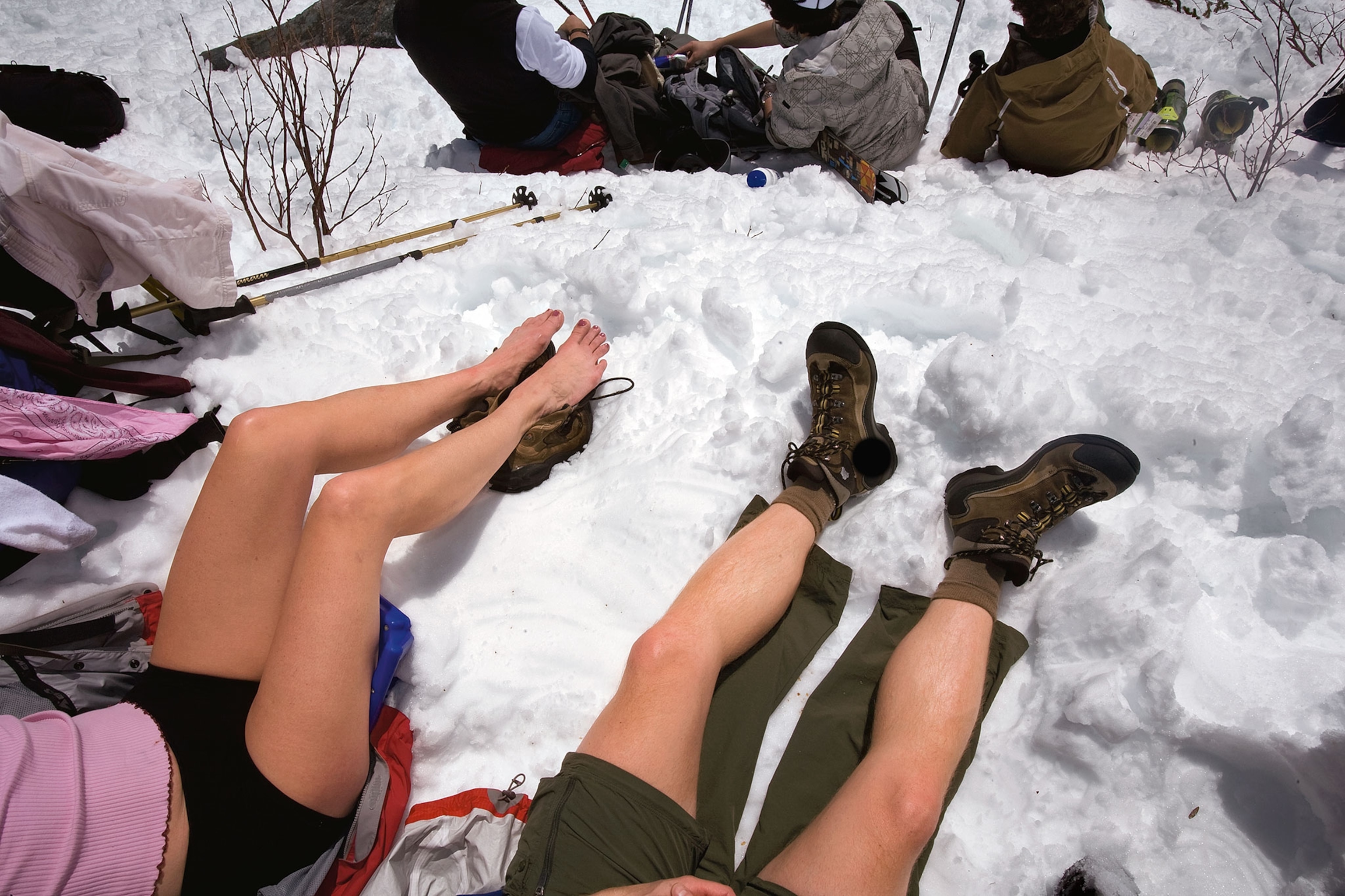 hikers in shorts sitting in the snow
