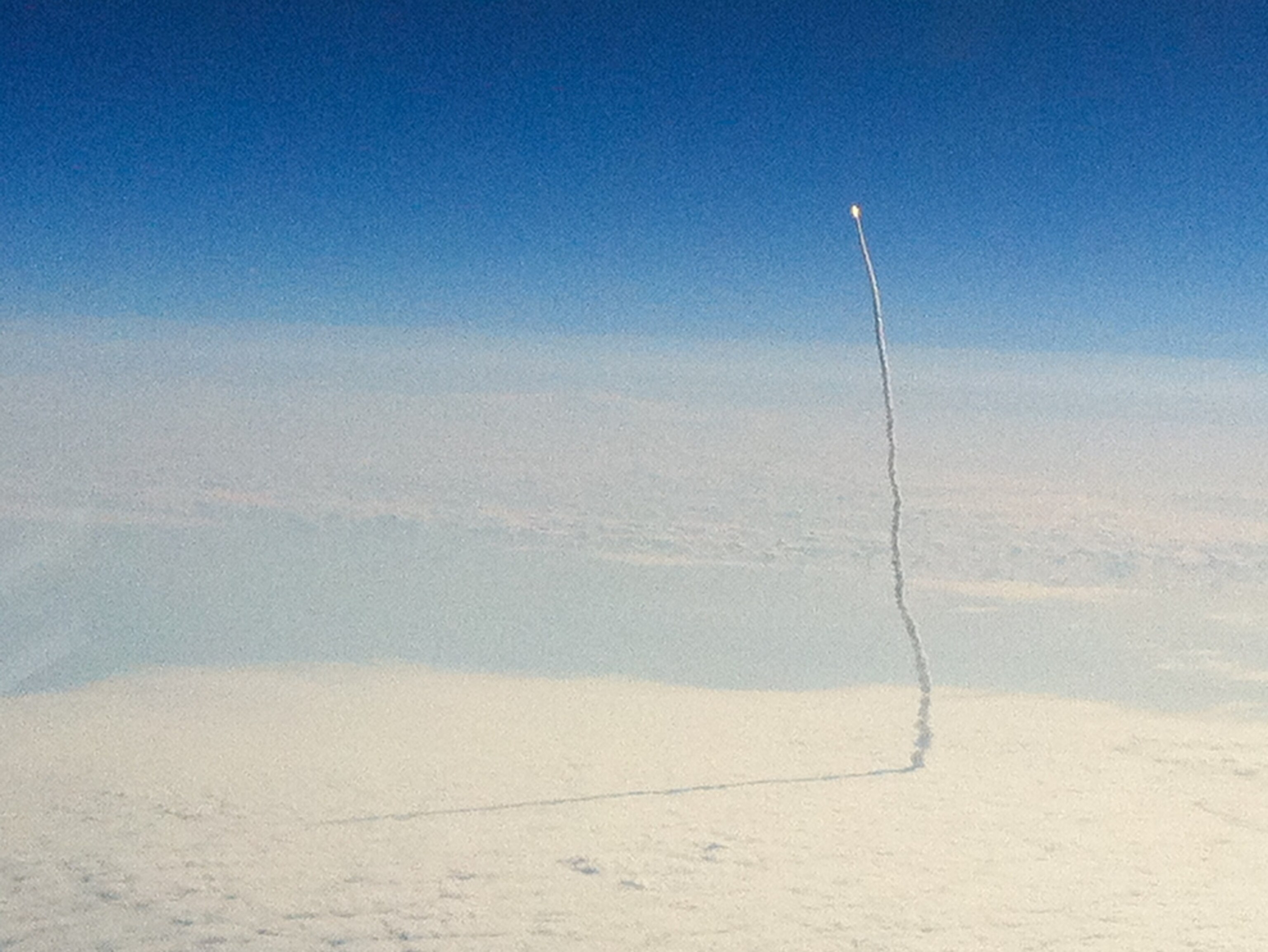 A picture taken from an airplane shows the space shuttle Endeavour launching from Kennedy Space Center.