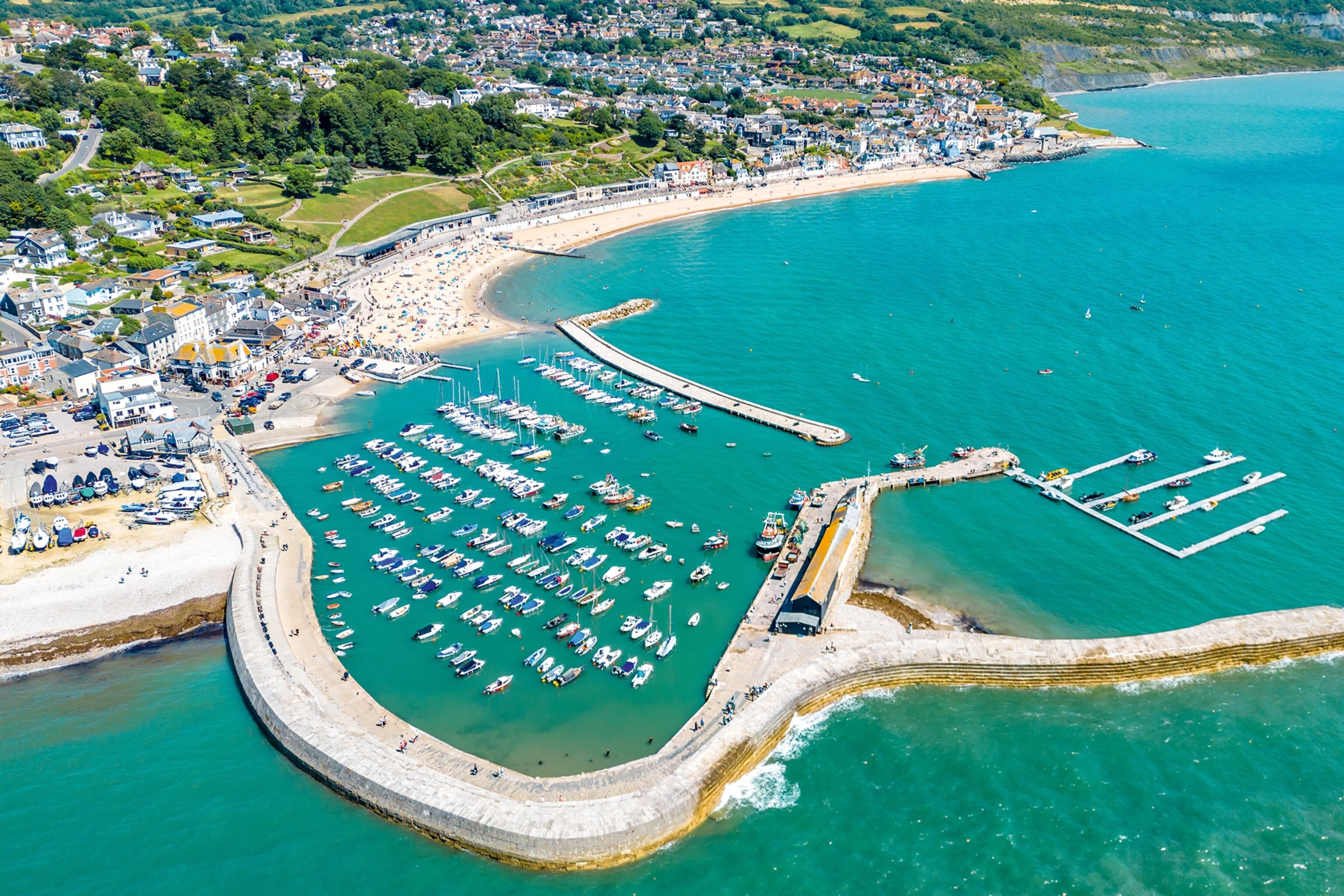 An aerial view over a harbour in a bay on the British coast line.