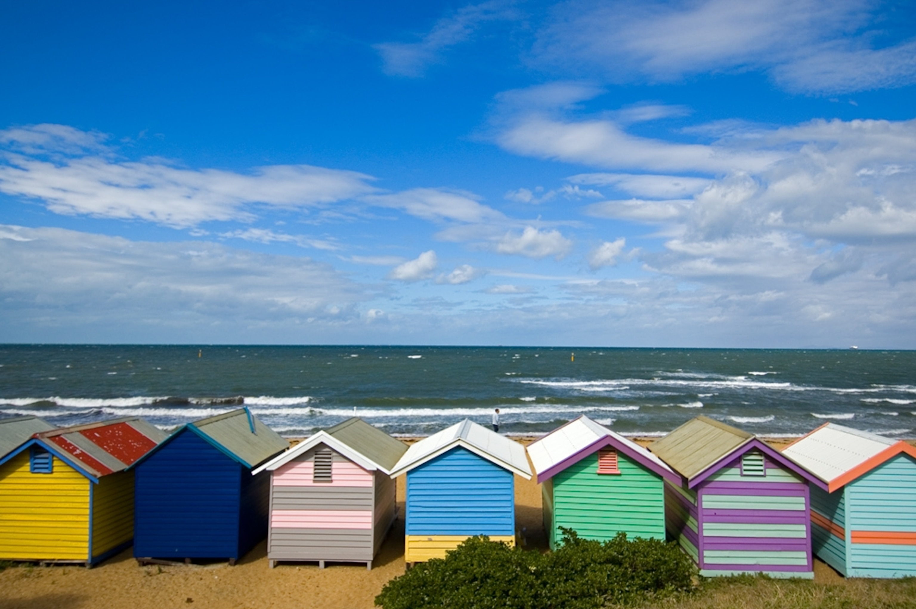 Colorful bath houses line the waterfront on Brighton beach.