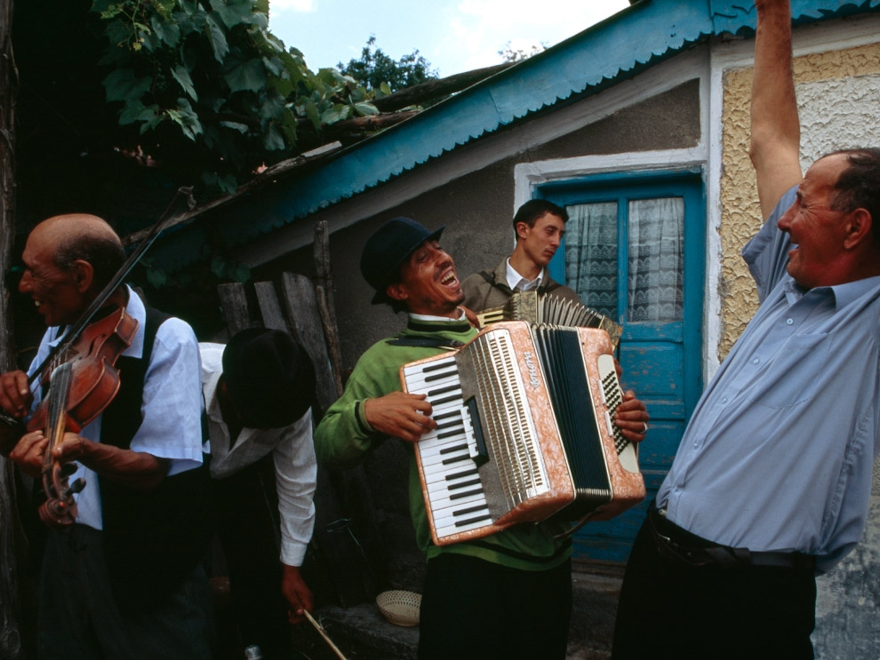 Men with instruments outside a house