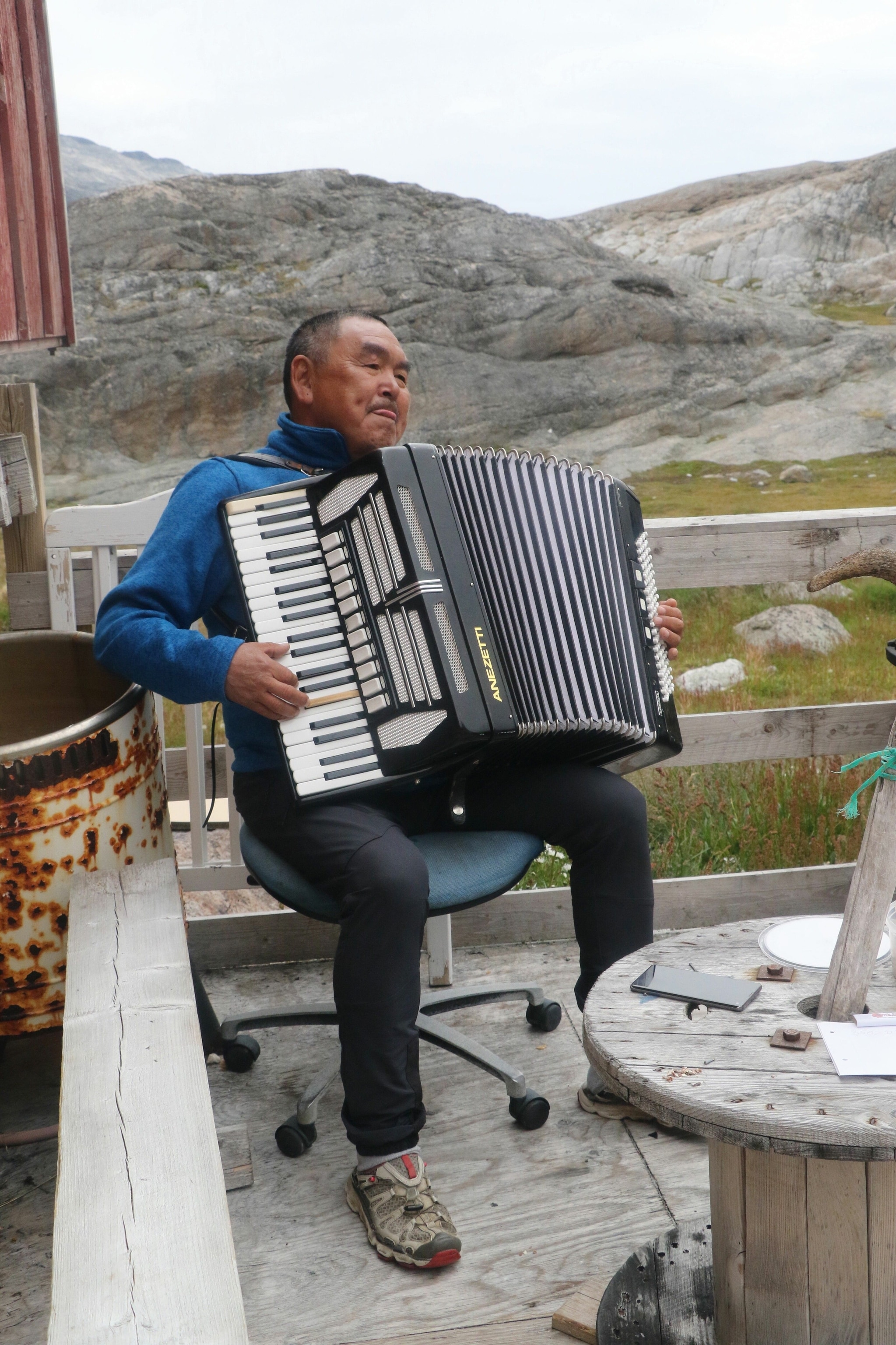 An Aappilatoq resident entertains visitors on the accordion.