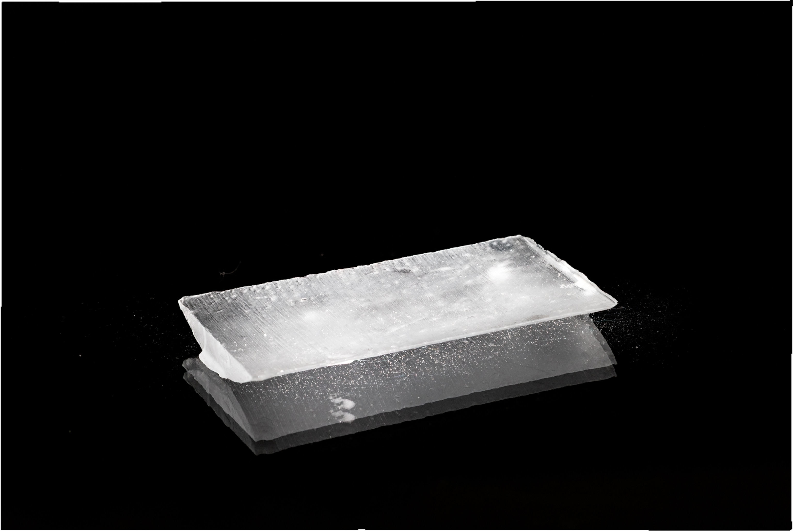 Ice plate on black background with a second layer looking like its reflection.