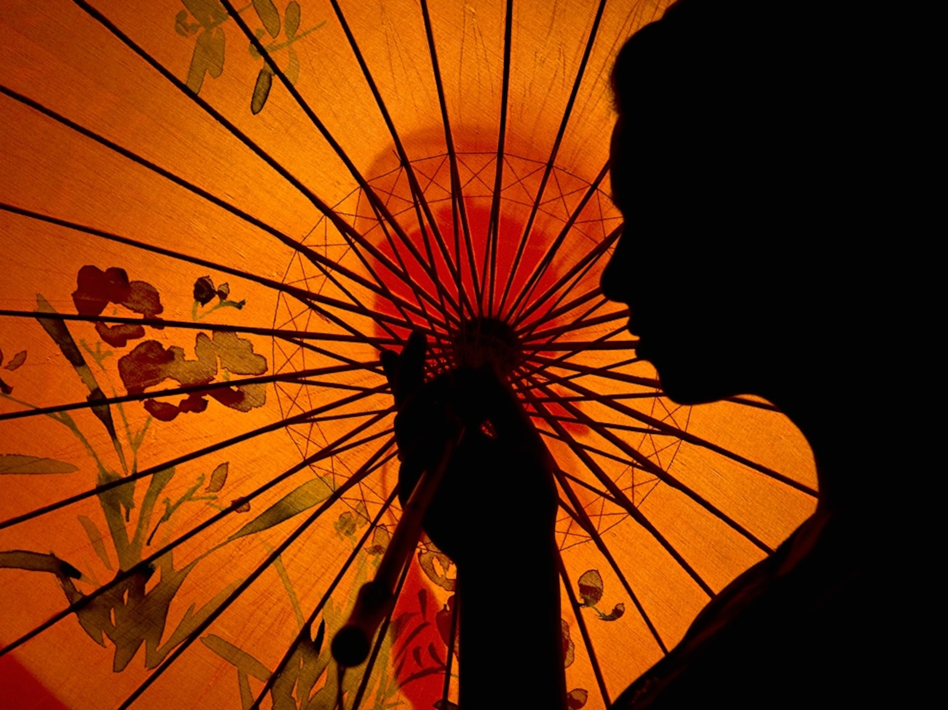 Woman’s silhouette in front of an orange parasol