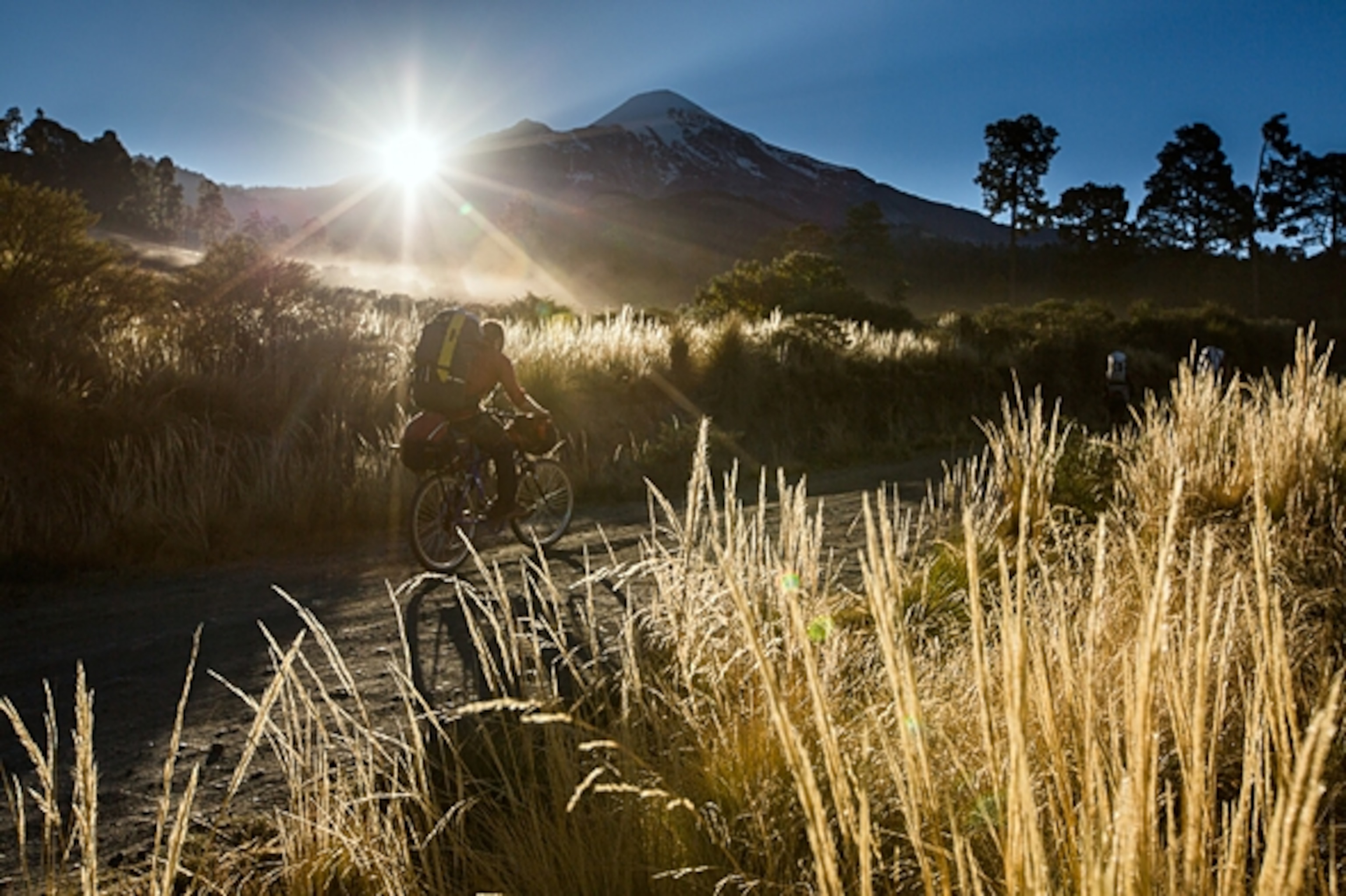 Todd Tumolo pedals switchbacks up Orizaba as the sun breaks over the horizon; Photograph by Jim Harris