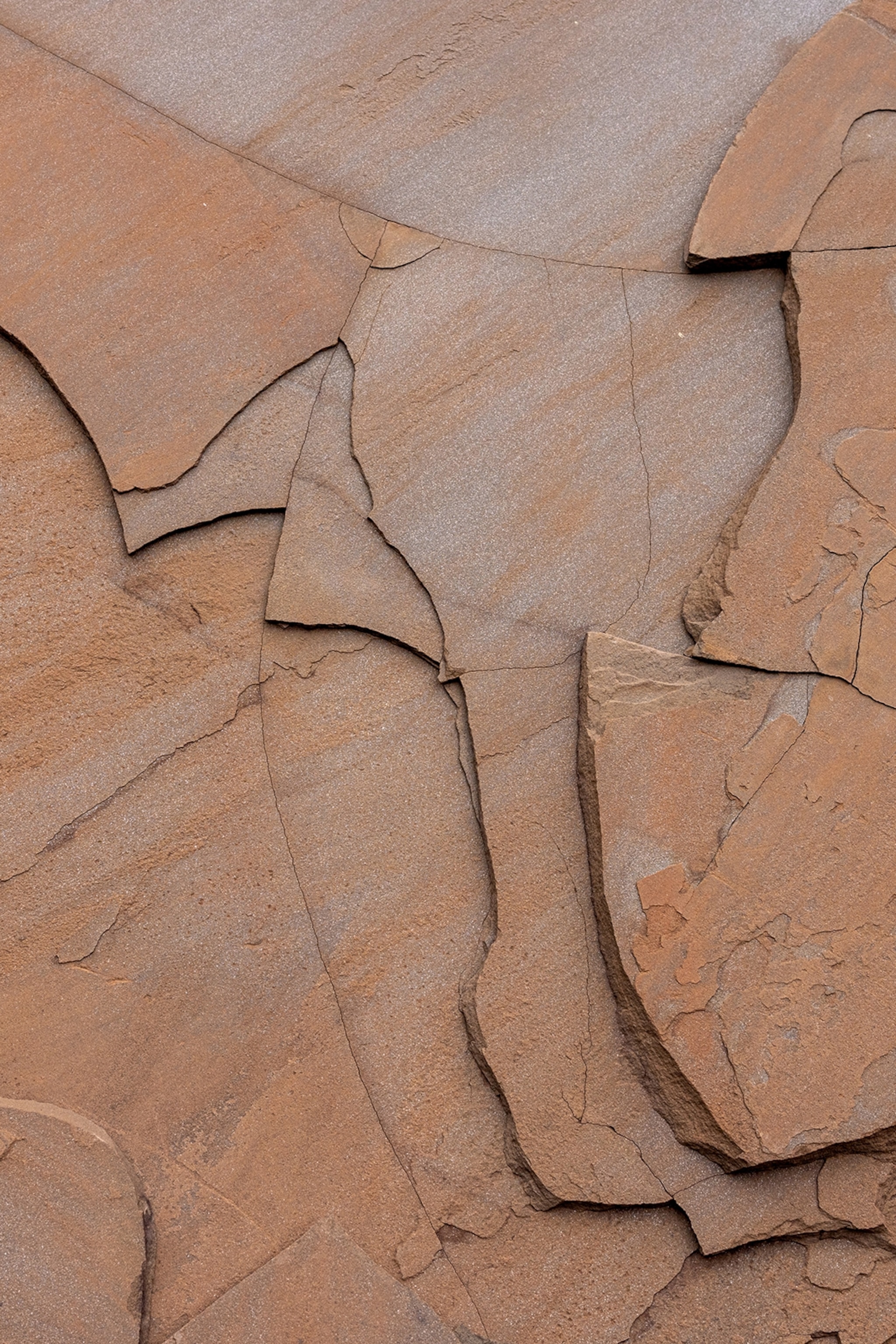 A close-up of rock plates on a canyon wall, half-broken.