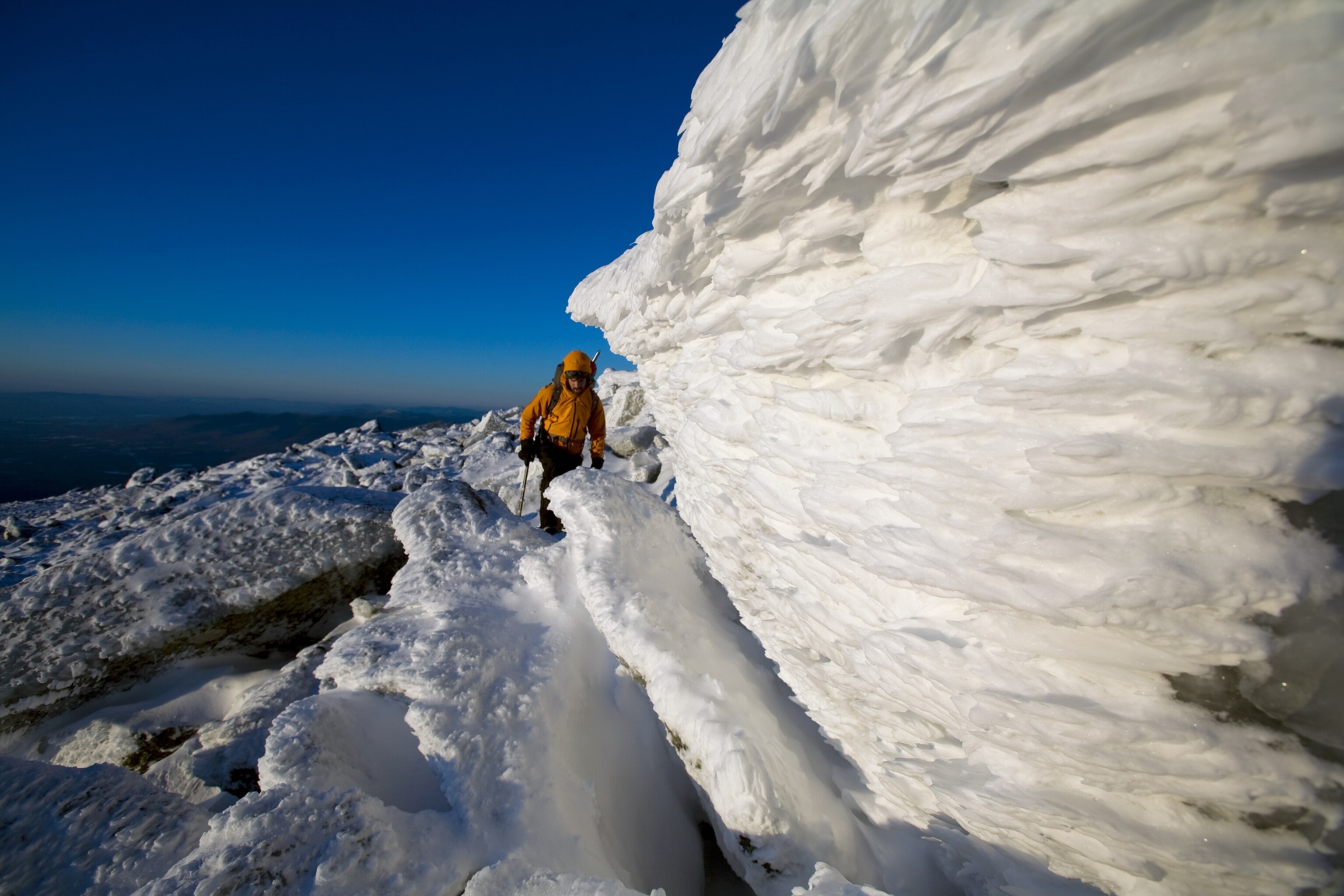 Ryan Buckley hiking through a jumble of icy boulders near the mountain's summit