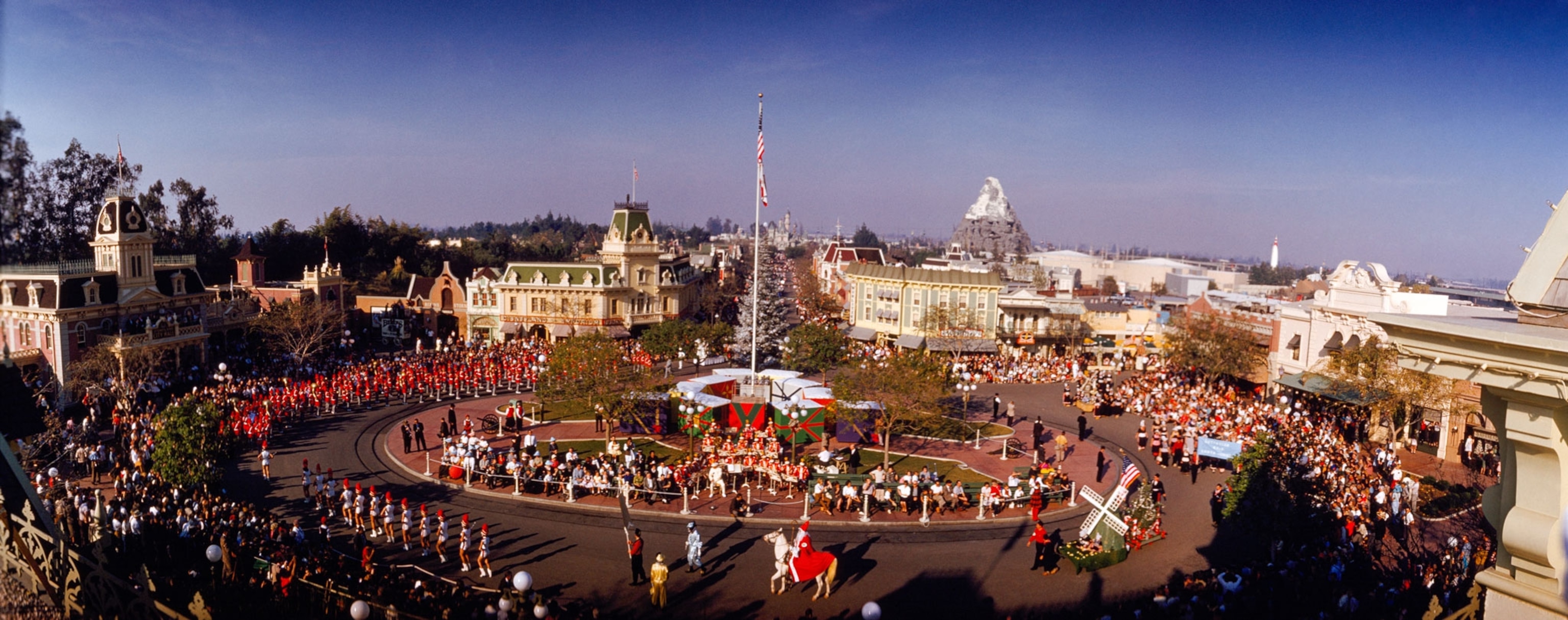 Disneyland, California. An aerial view of the main plaza in Disneyland, with a group of people watching entertainers.photo from 1960