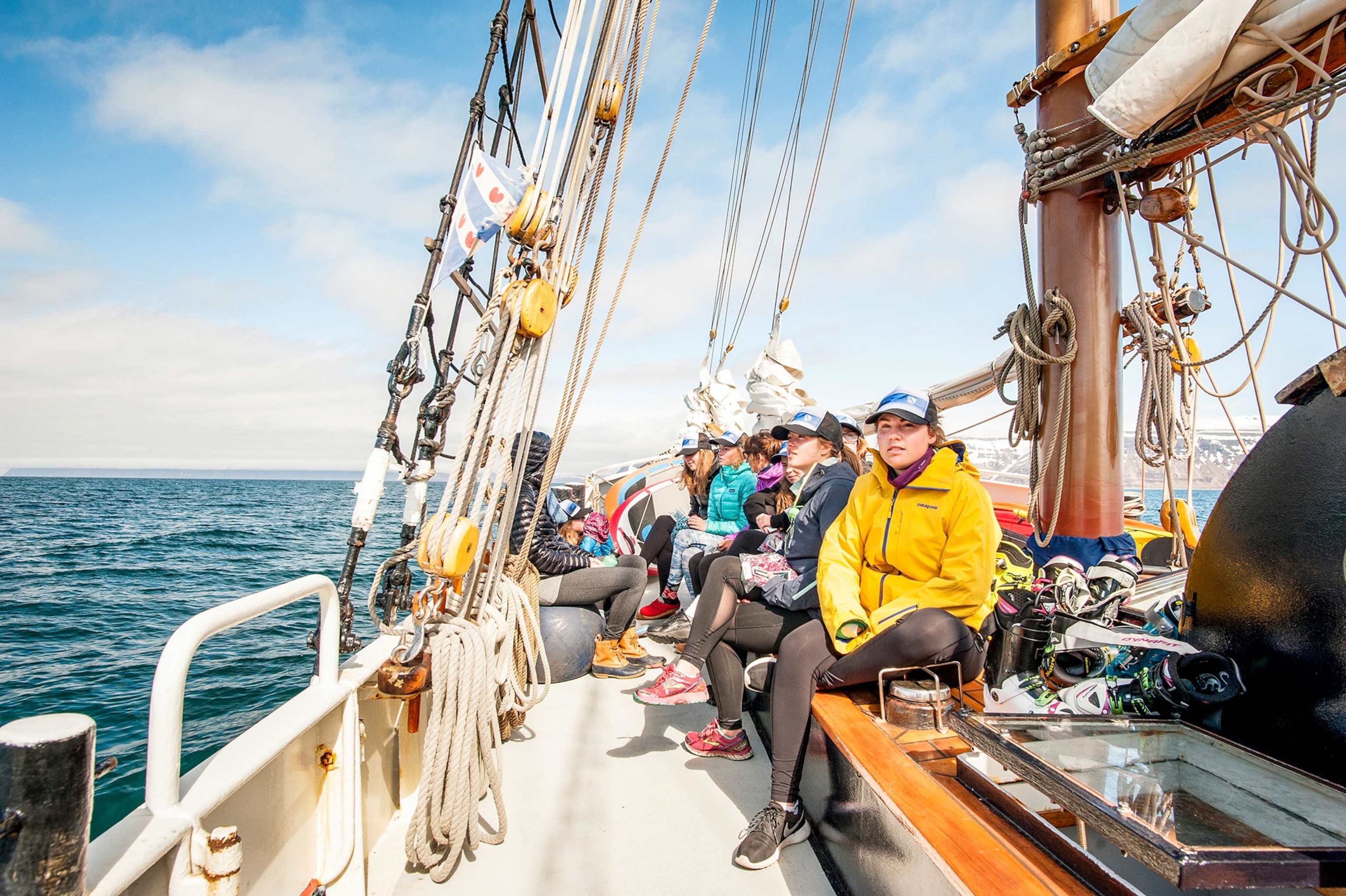 a group of skiers being ferried on a sailboat to a remote location for skiing in Iceland
