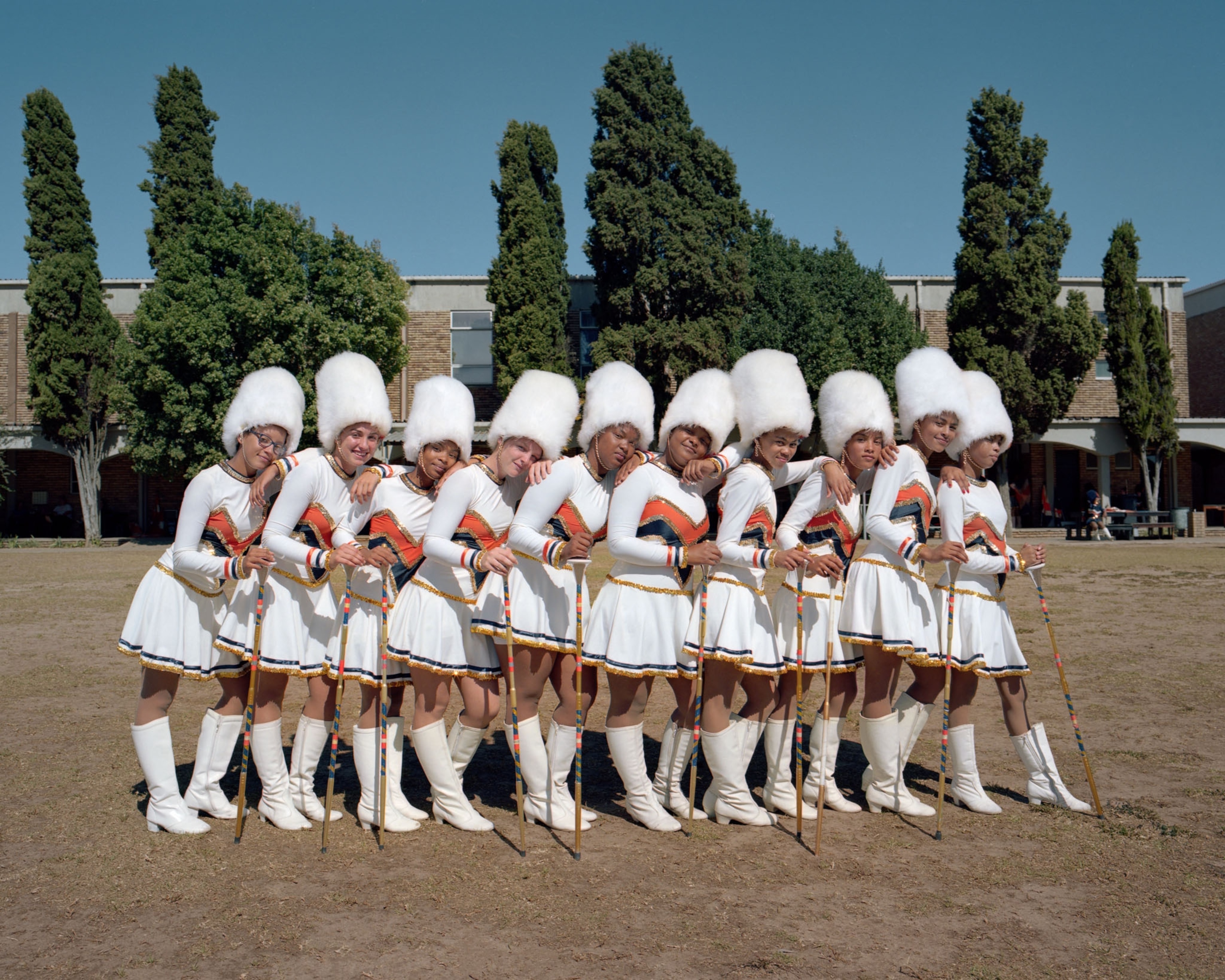 ten high school girls in white uniforms standing in a line