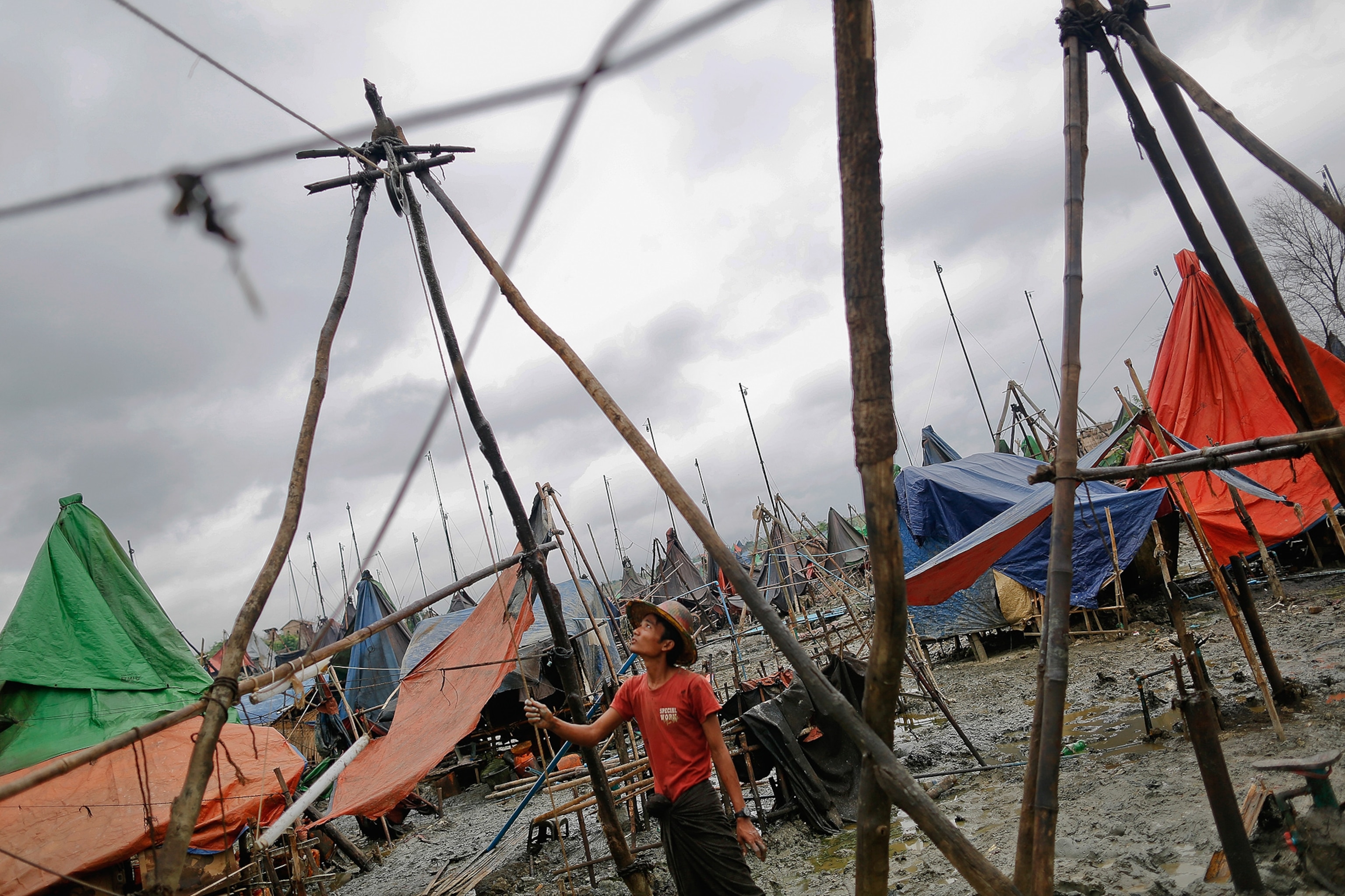 a man operating basic machinery to extract oil from a well in the Minhla township of the Magwe in Myanmar.