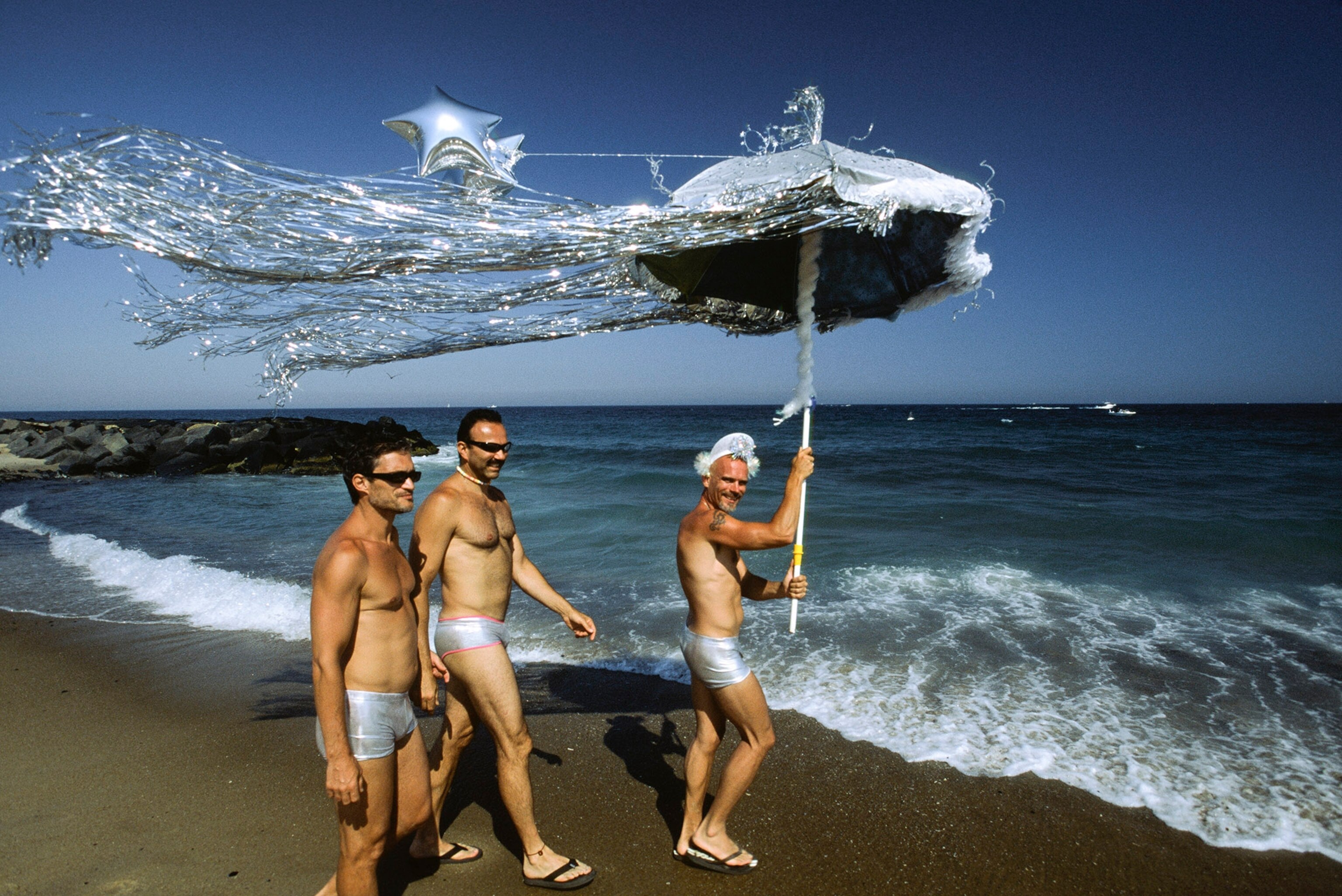 men on a beach with an umbrella