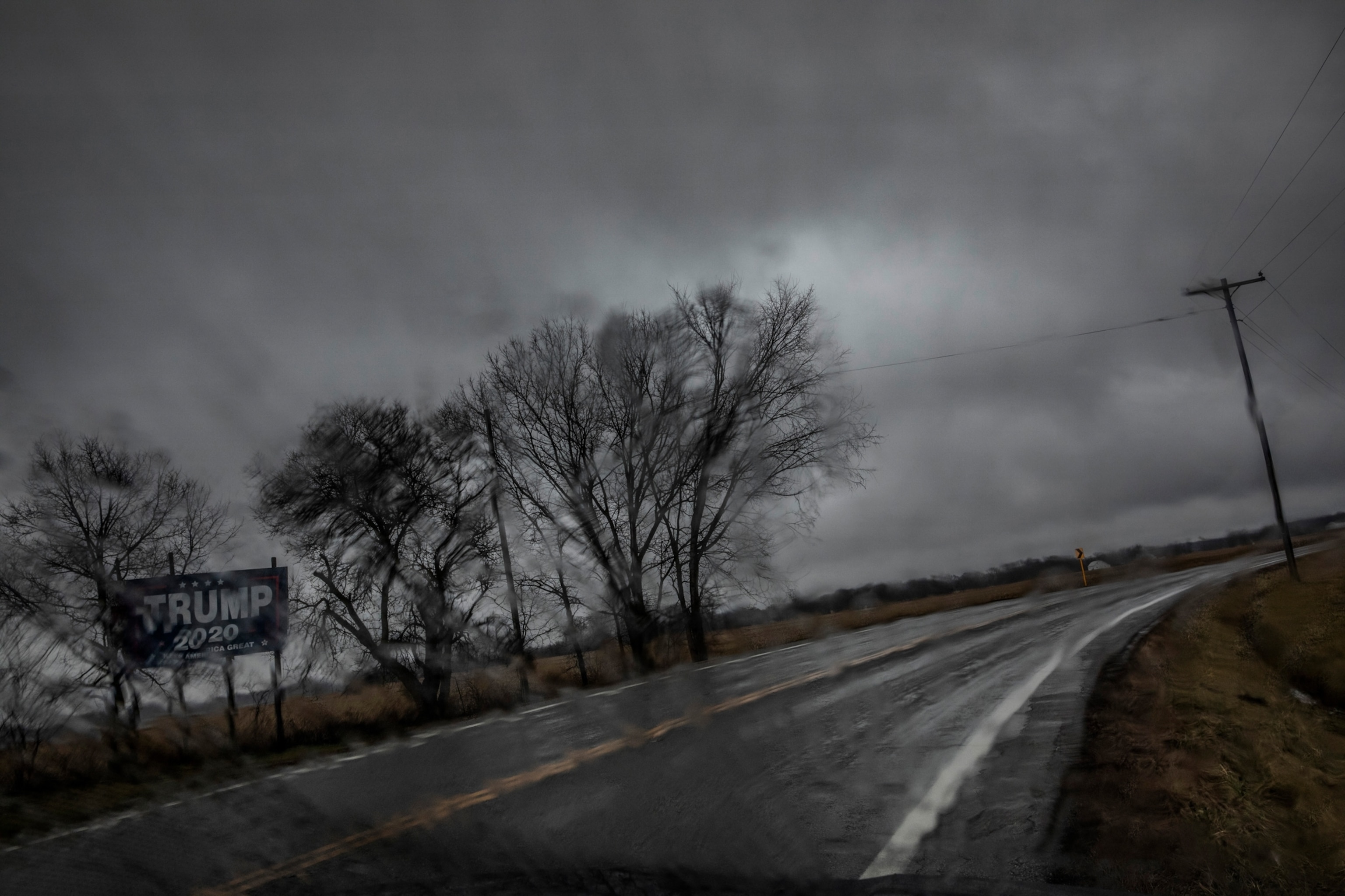 A Trump campaign billboard stands in the rain along a highway