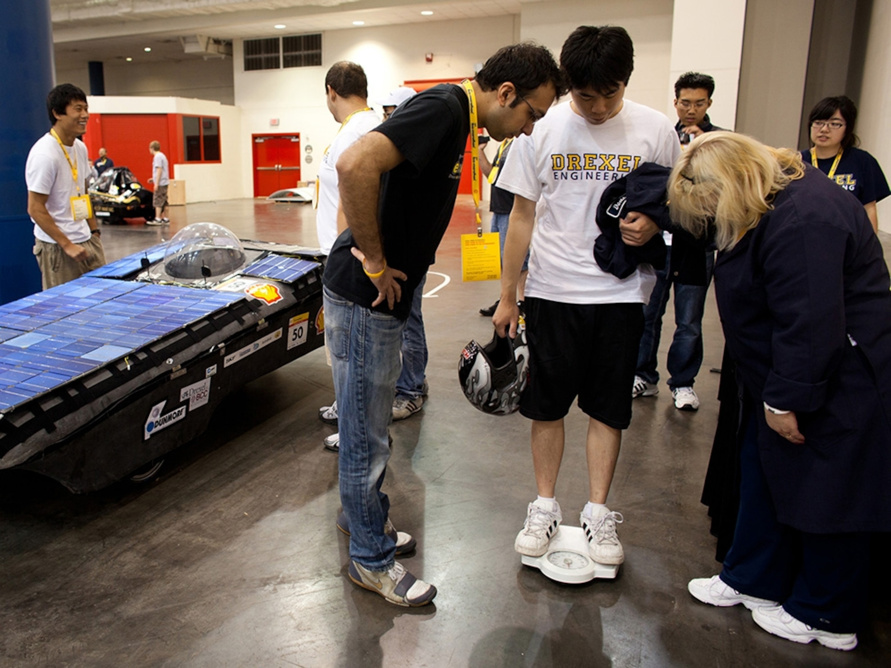 Drexel University driver Conjee Yeung stands on a scale while Shell volunteer Mary Van Rossen, right, checks whether he is heavy enough to meet the weight requirements.
