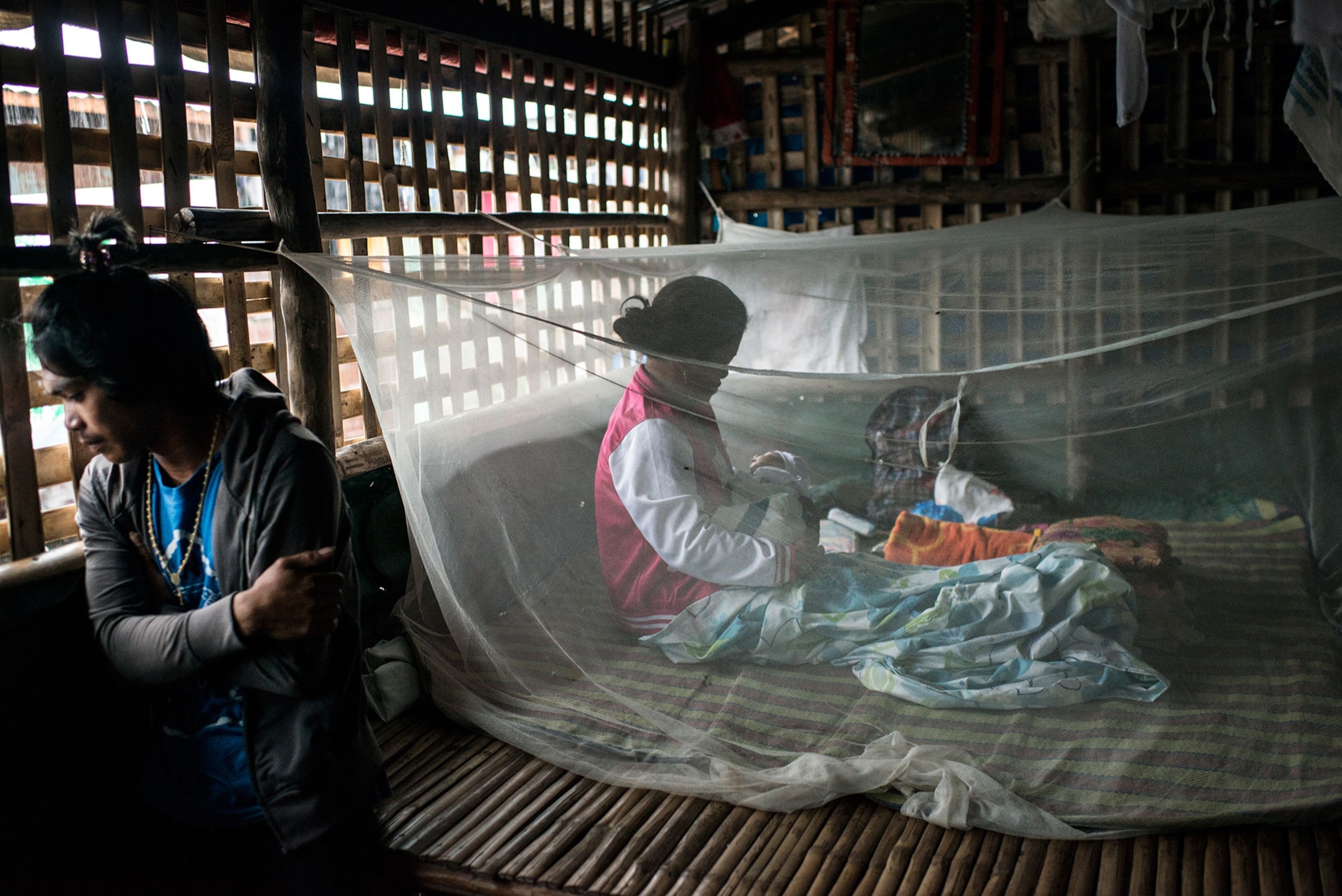 woman breastfeeding under mosquito netting