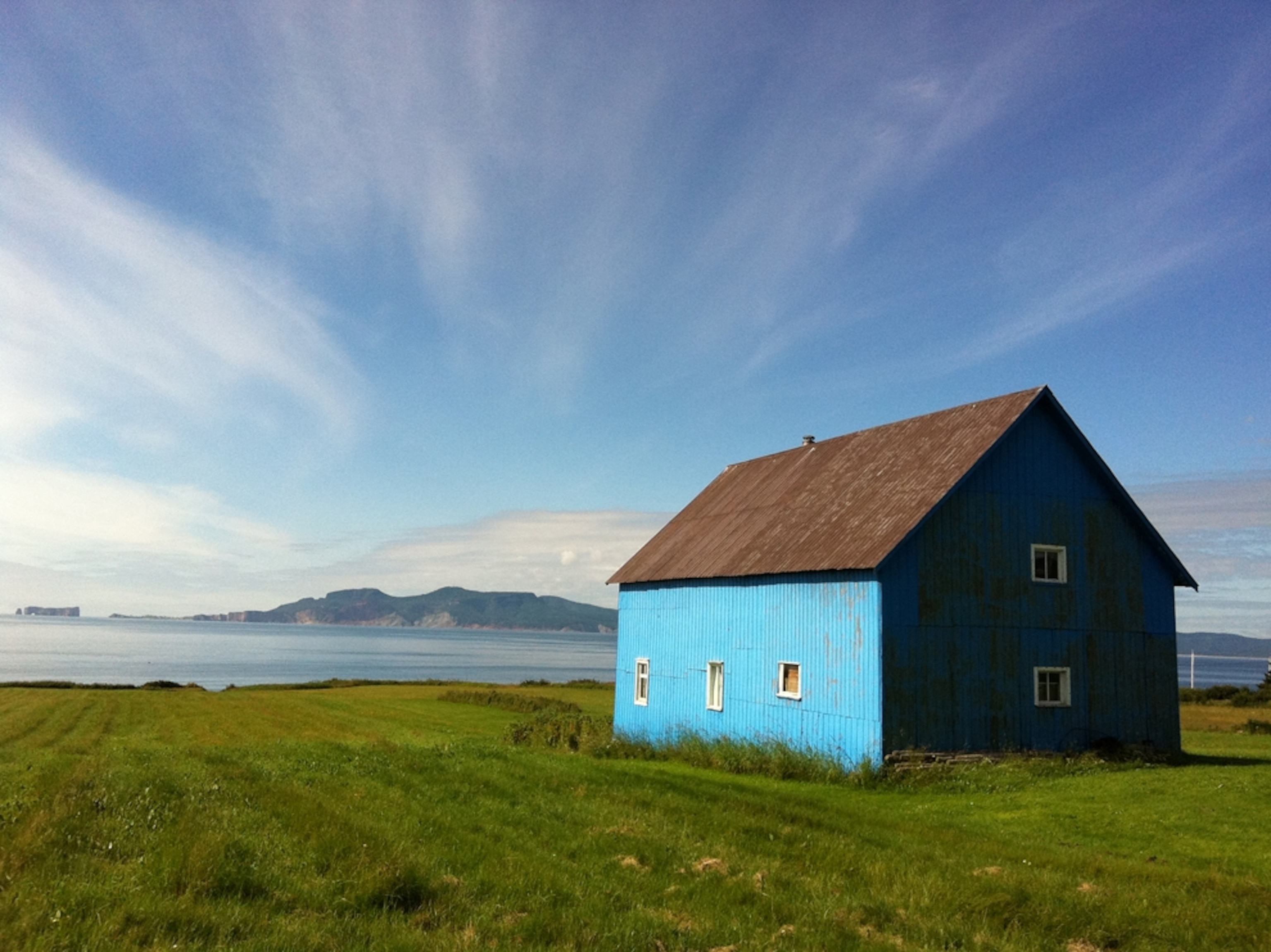 painted blue house in Gapse field, Quebec