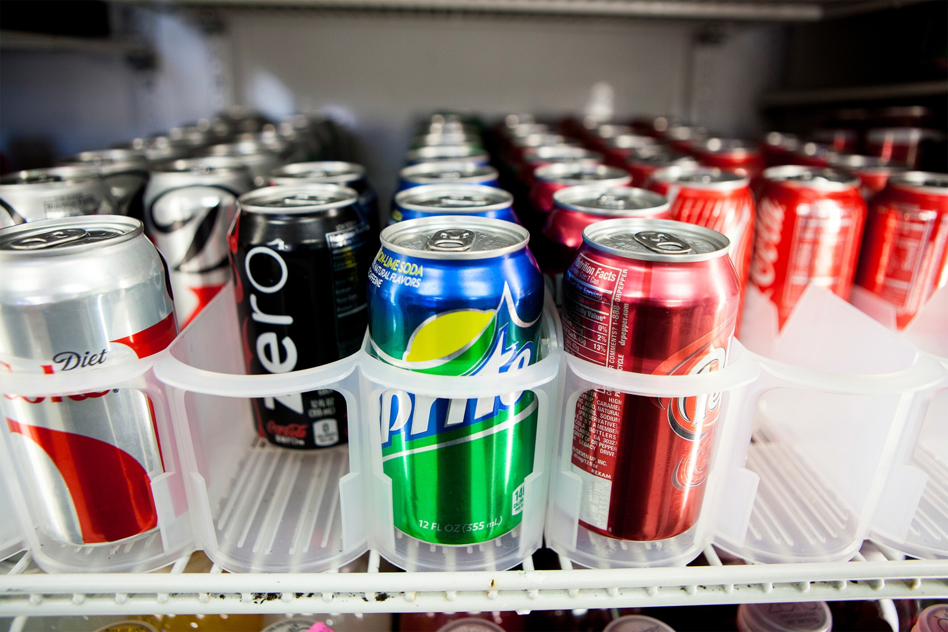 cans of soda displayed in a case at a convenience store in San Diego.