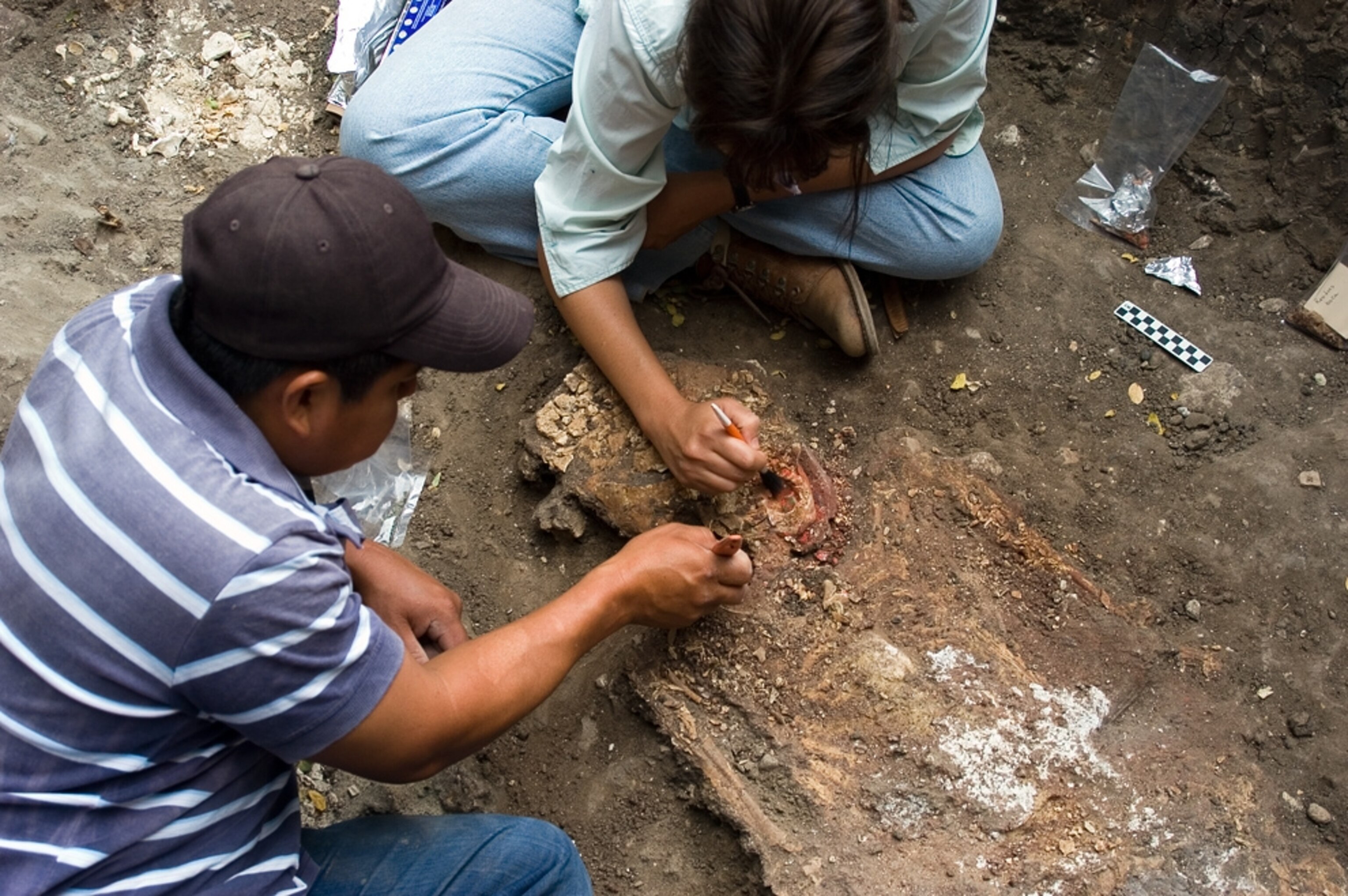 Archaeologists clean a skull at the oldest known pyramid tomb in Mesoamerica.