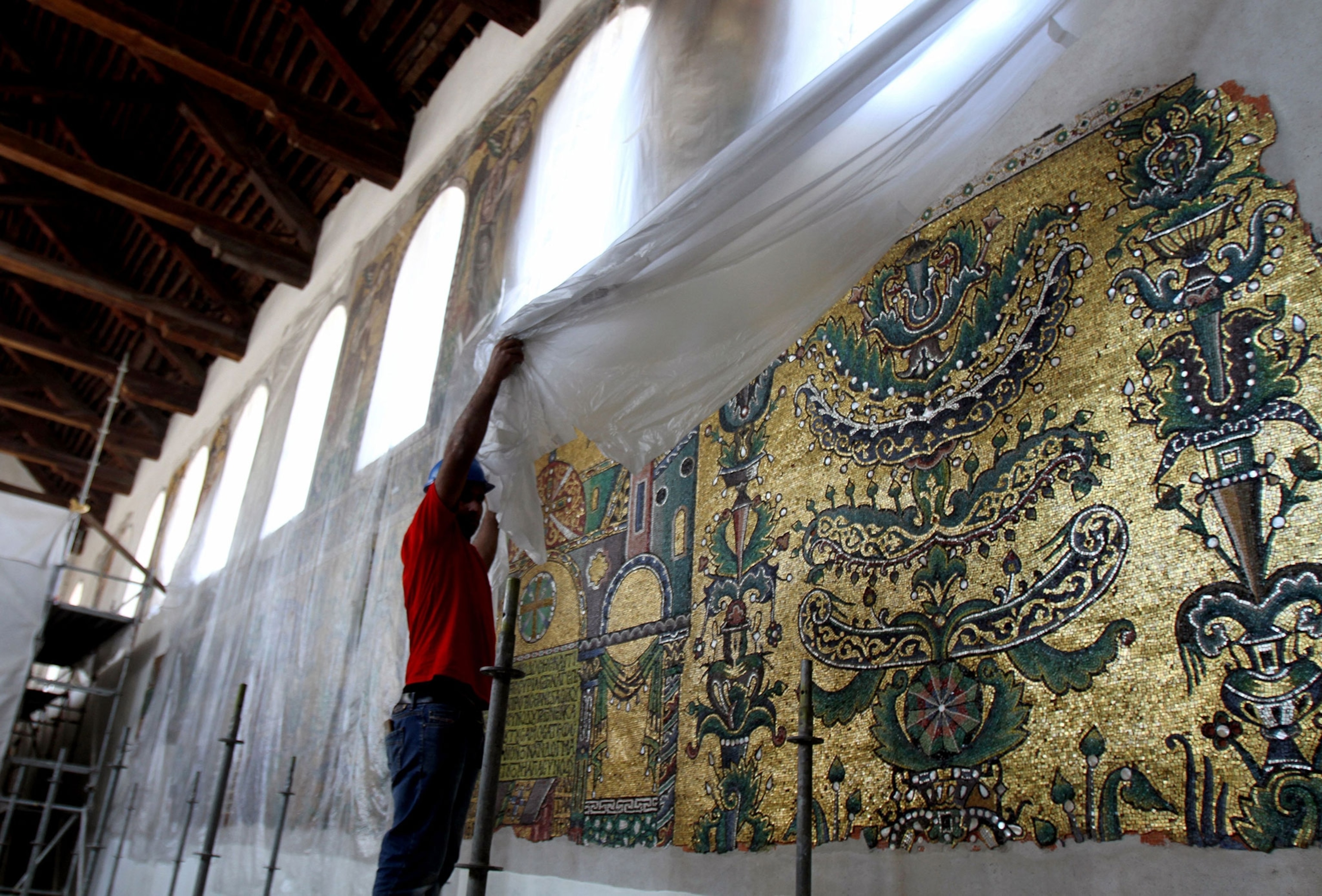 a worker moves a plastic cover to show a wall of icons