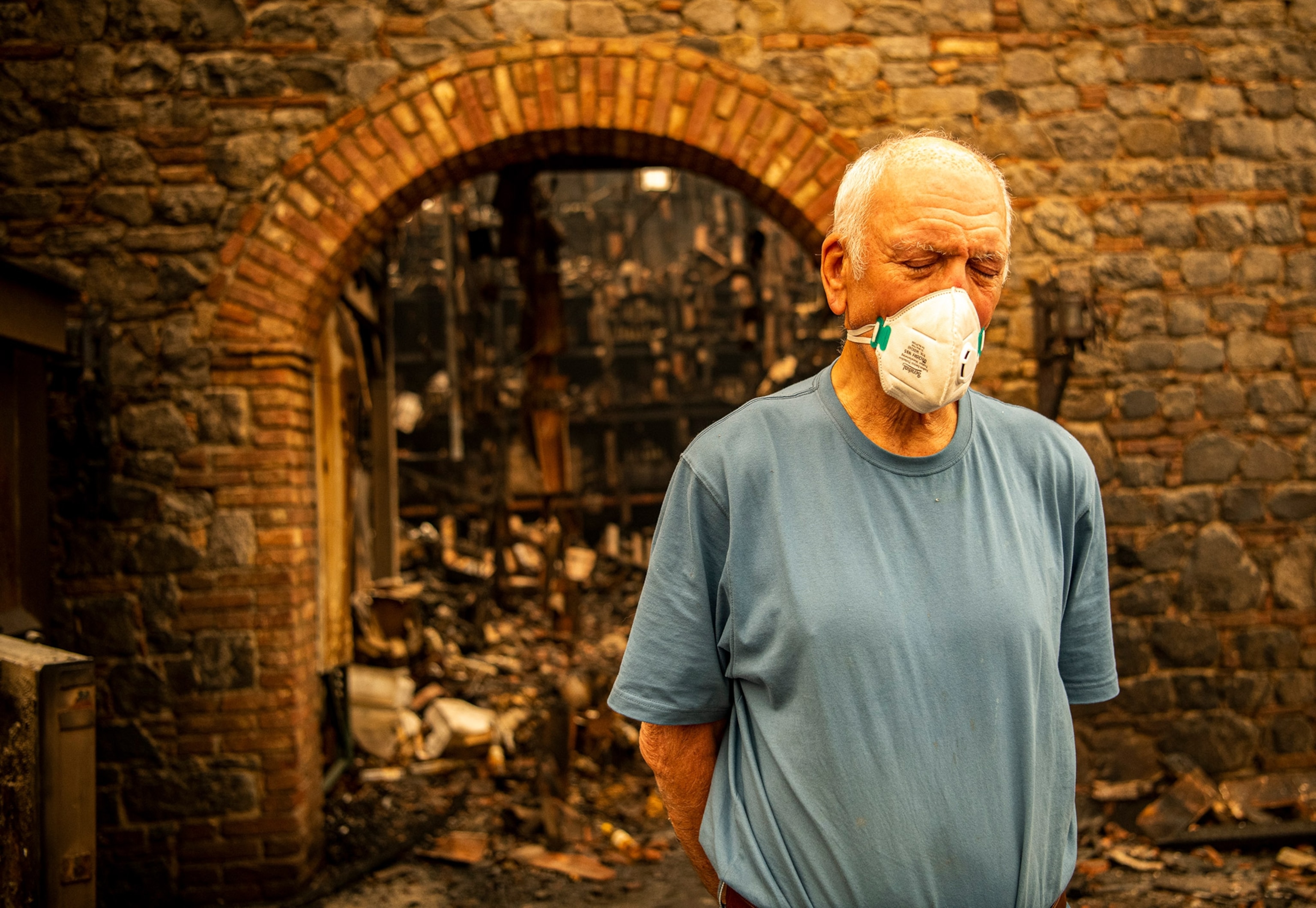 a winery owner standing in front of a burnt out winery in California