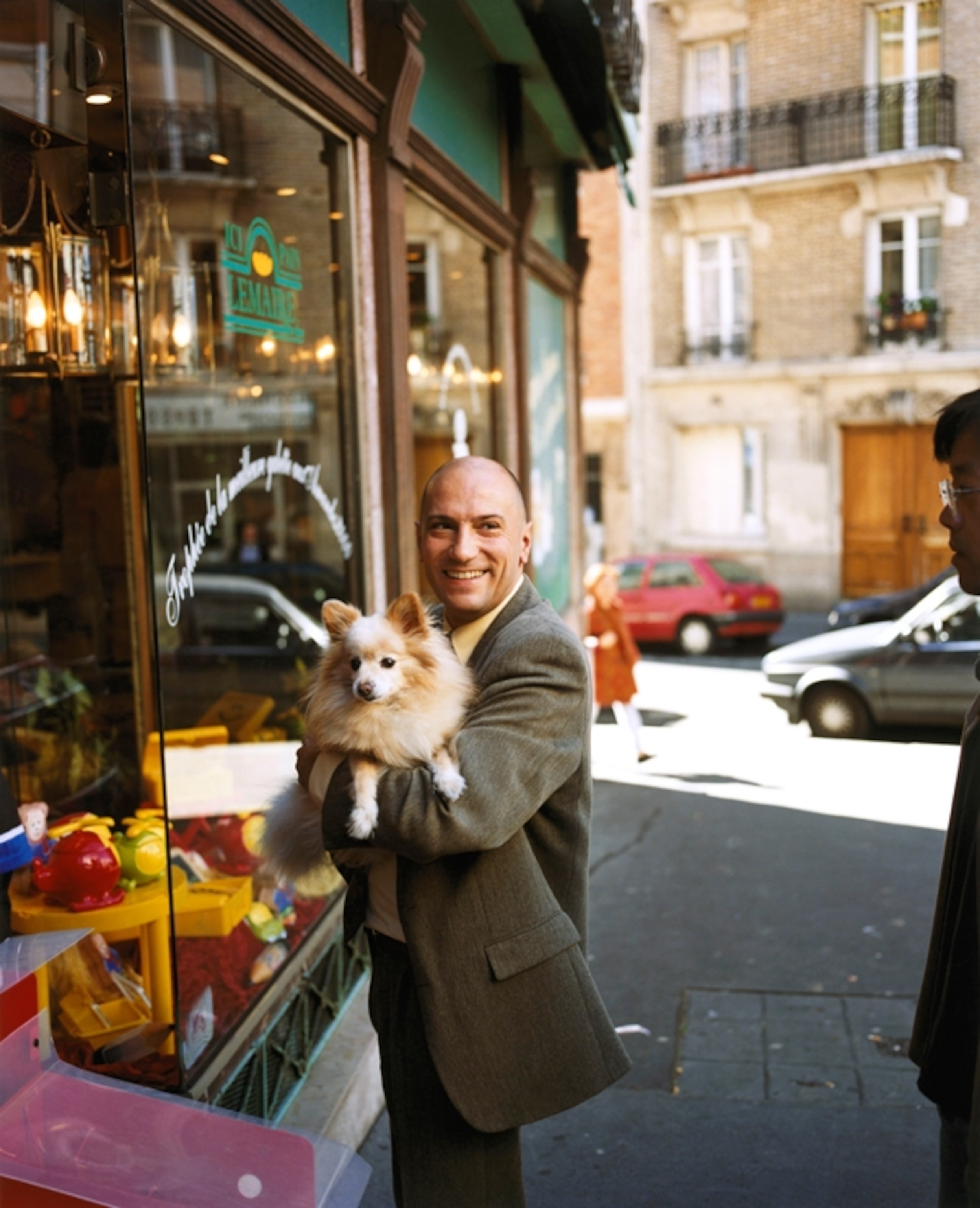 a man holding a small dog in Paris, France