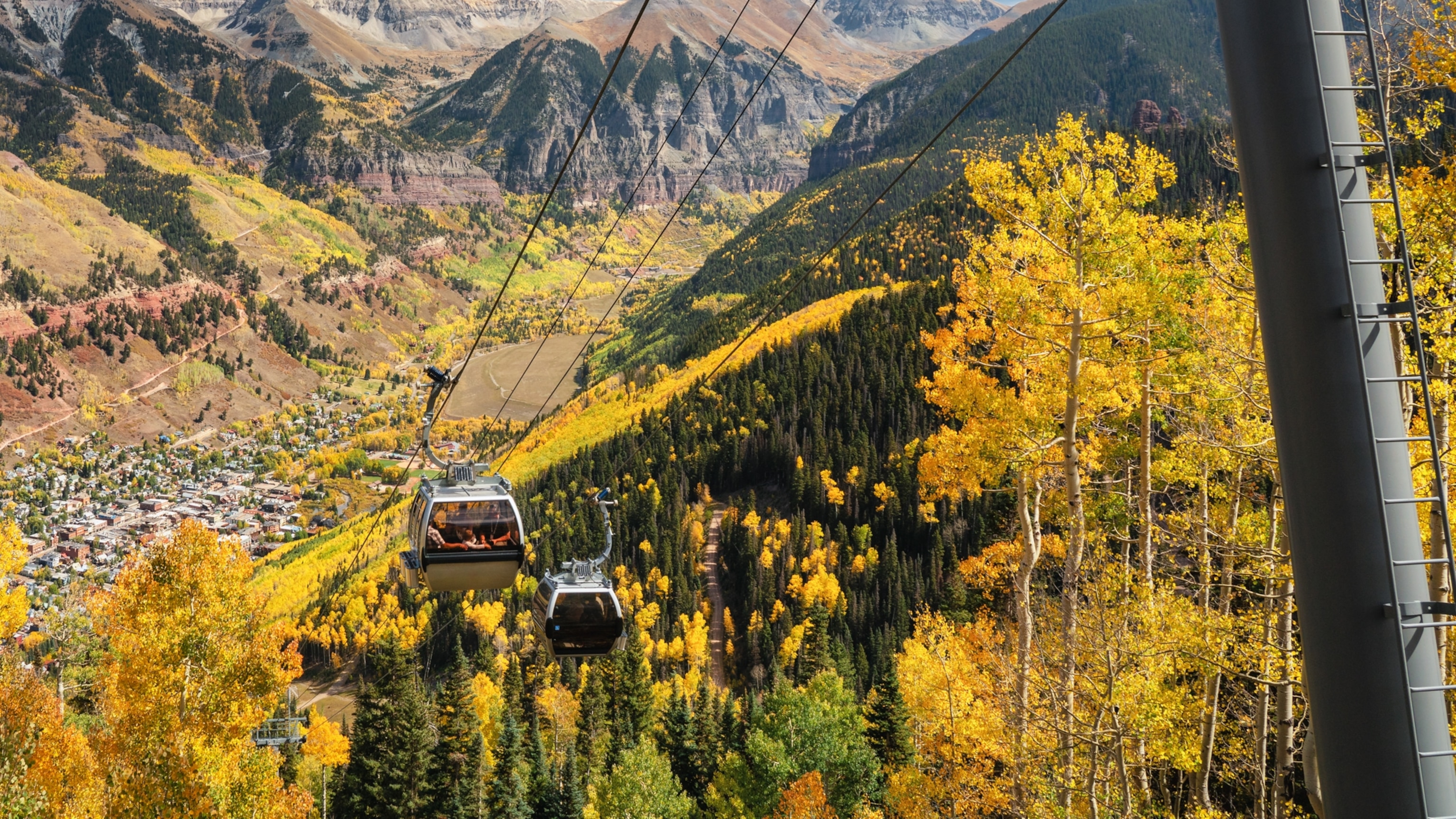 Yellow and orange trees surround the gondola in Telluride, Colorado.