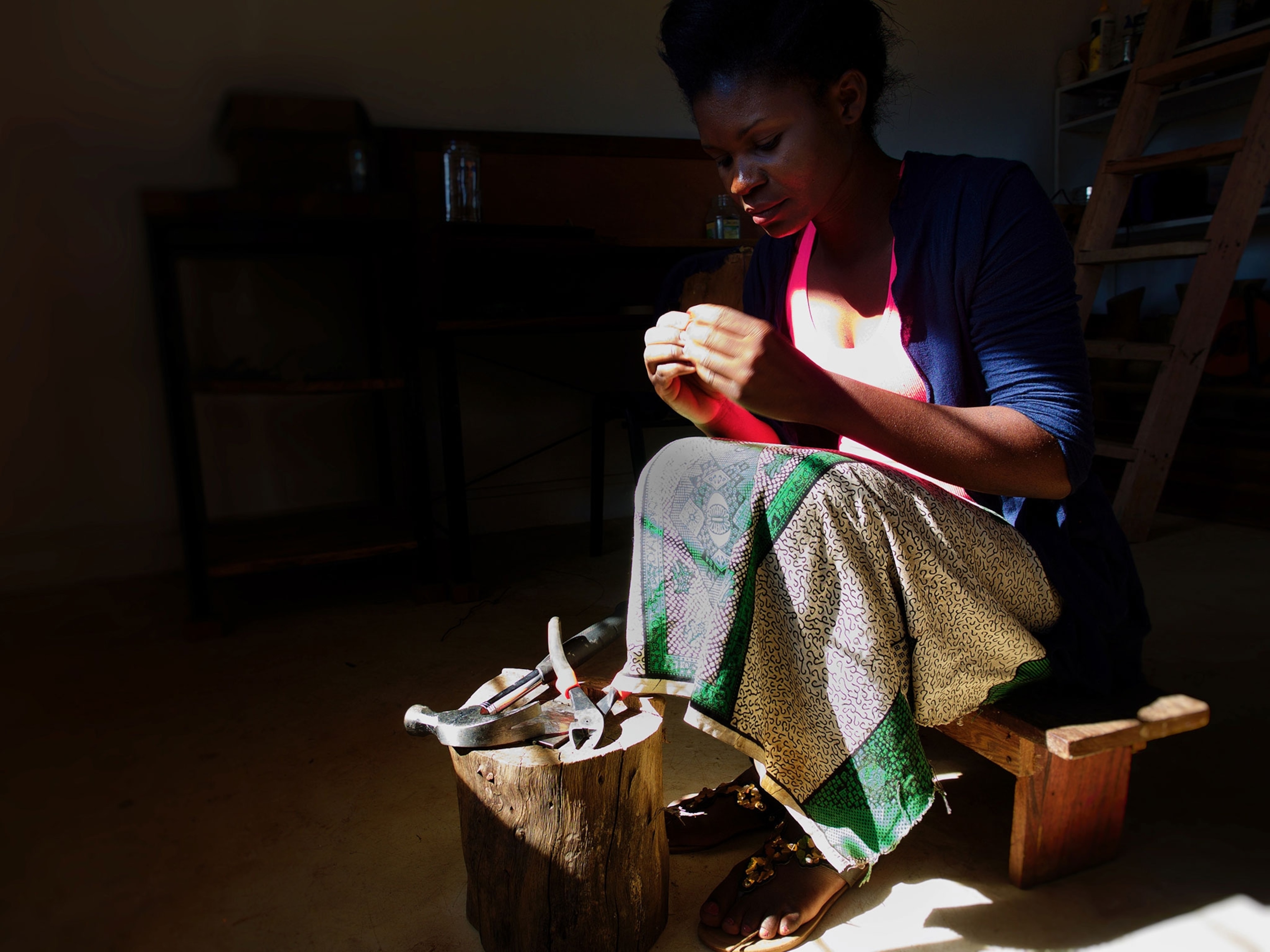 a local Zambian woman crafting jewelry