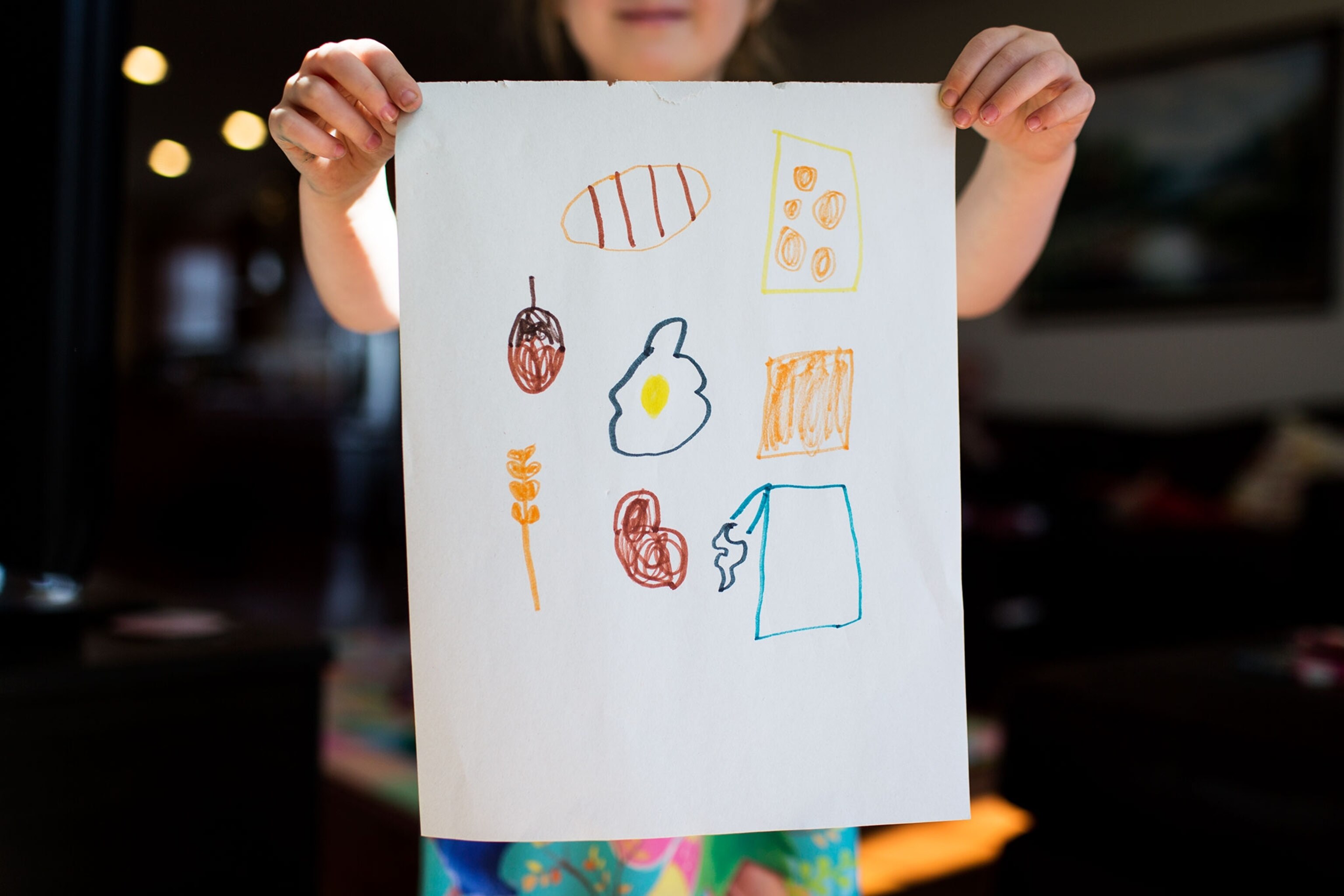 five-year-old Lily Hall holding a drawing of all the foods she's allergic to