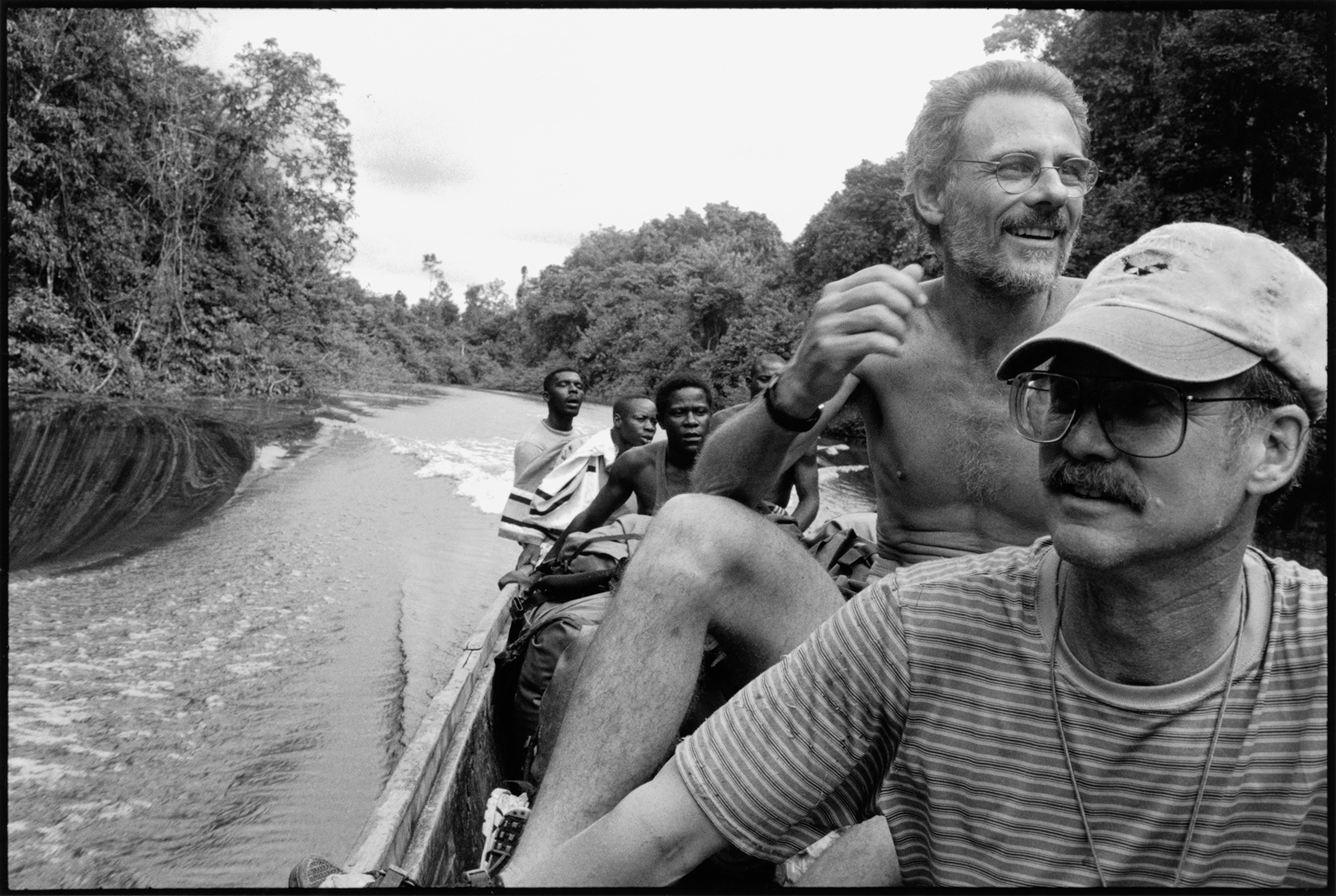 a man grieving as he watches members of the Red Cross burial team carrying the body of his father suspected of dying of Ebola.