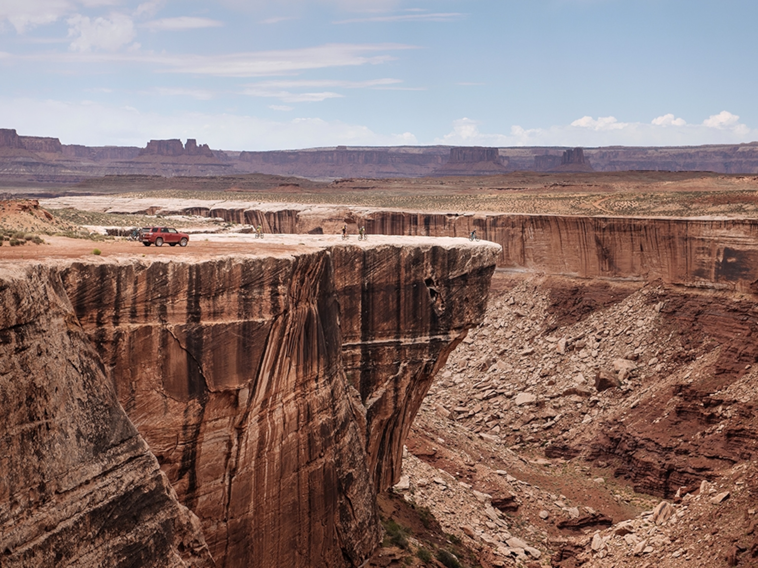 a group of adventures looking off the ledge of a cliff.